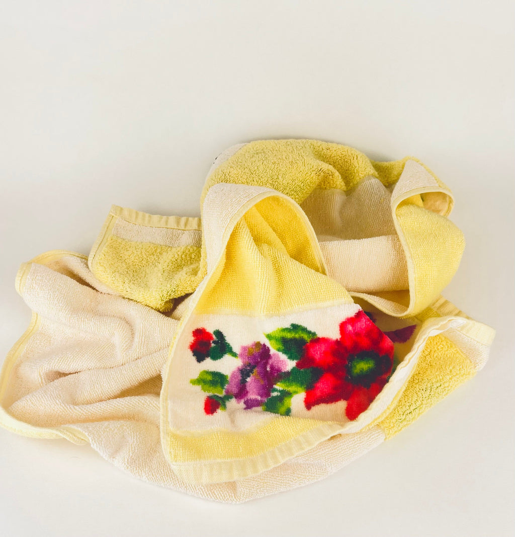 Yellow towel with floral embroidery on a white background