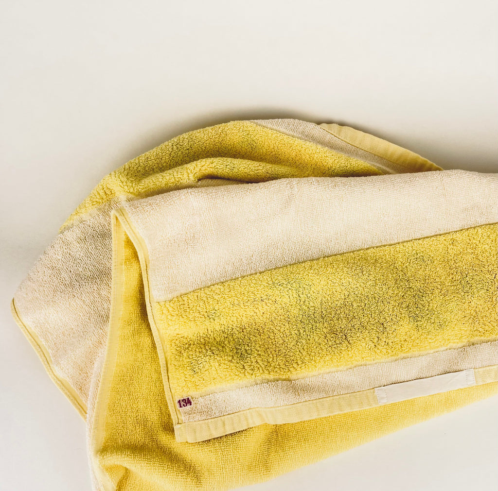 Yellow and beige striped towel on a white background
