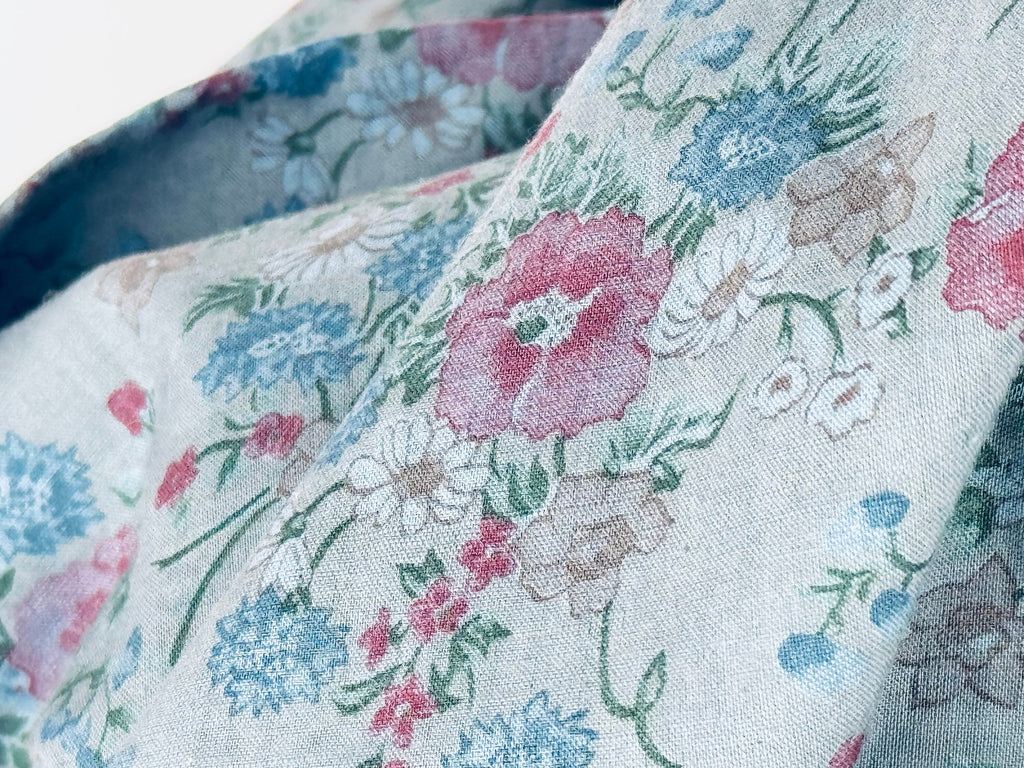 Floral patterned fabric with pink, blue, and green flowers on a light background