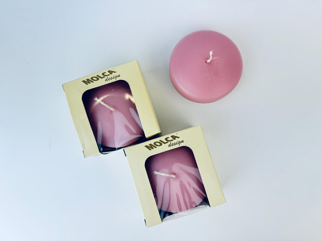 Pink candle with 'Molca' packaging on a light background