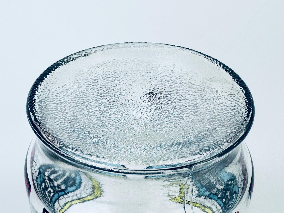 Clear glass jar with decorative bottom on a white background