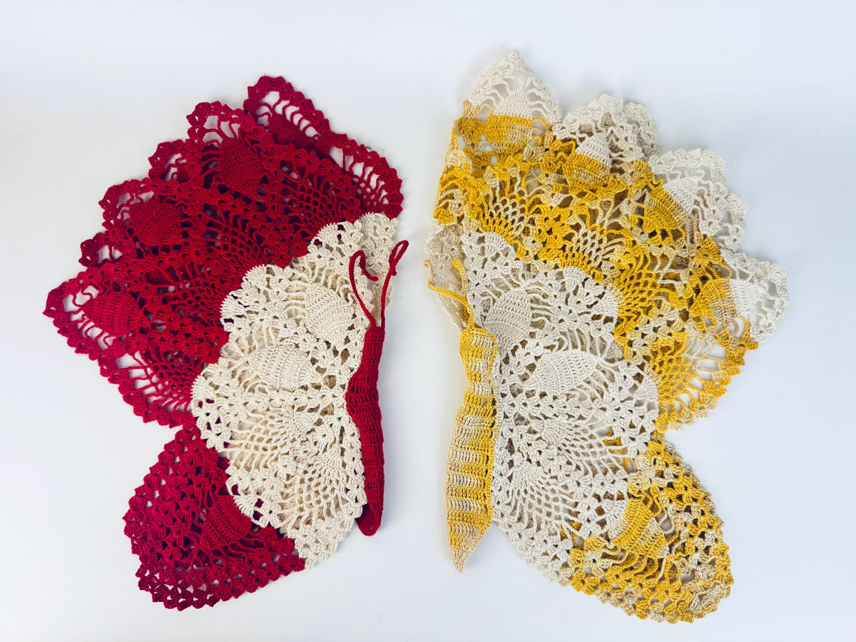 Crimson and yellow butterfly doilies layered together, viewed diagonally