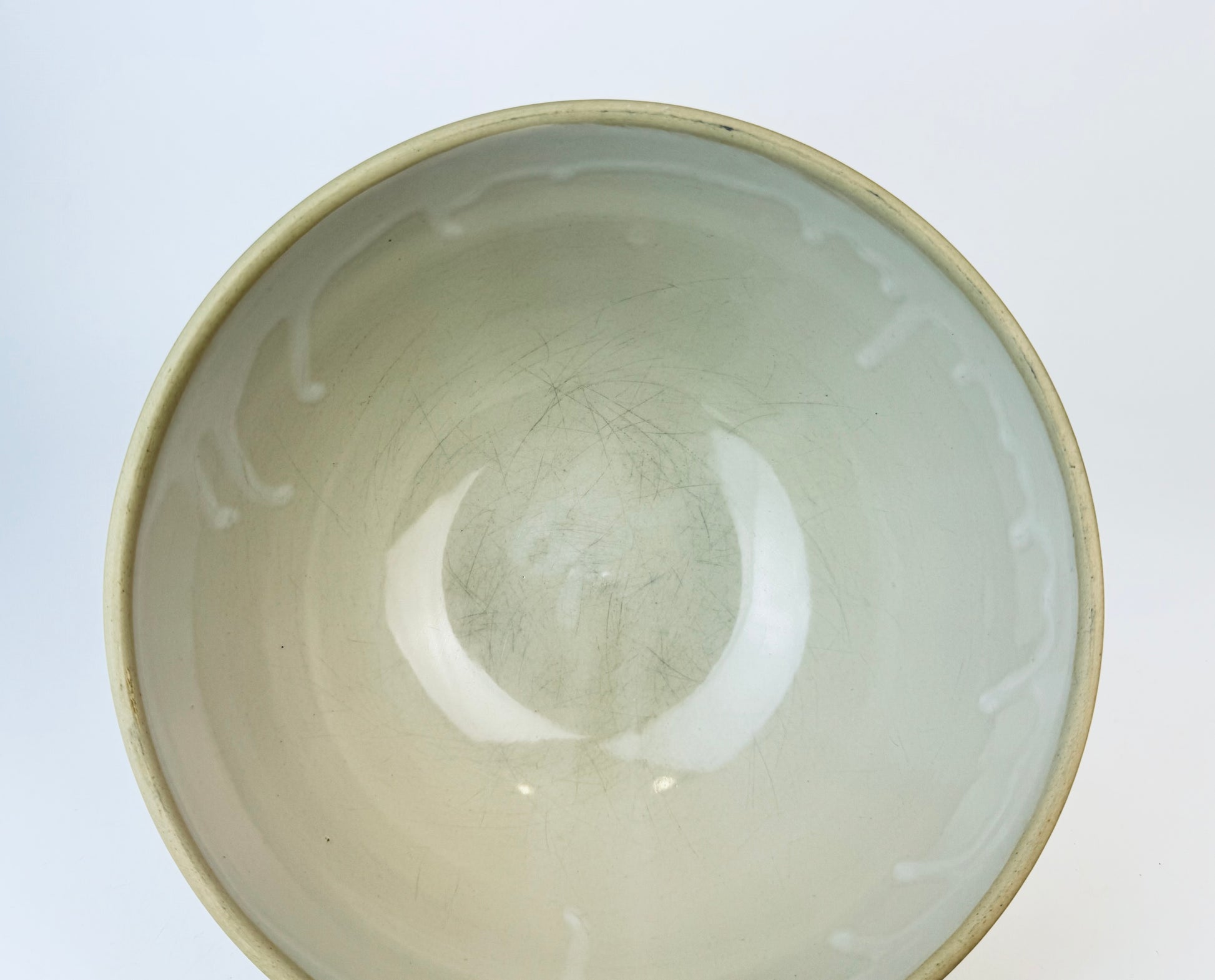 Close-up of a ceramic bowl with a light glaze on a white background
