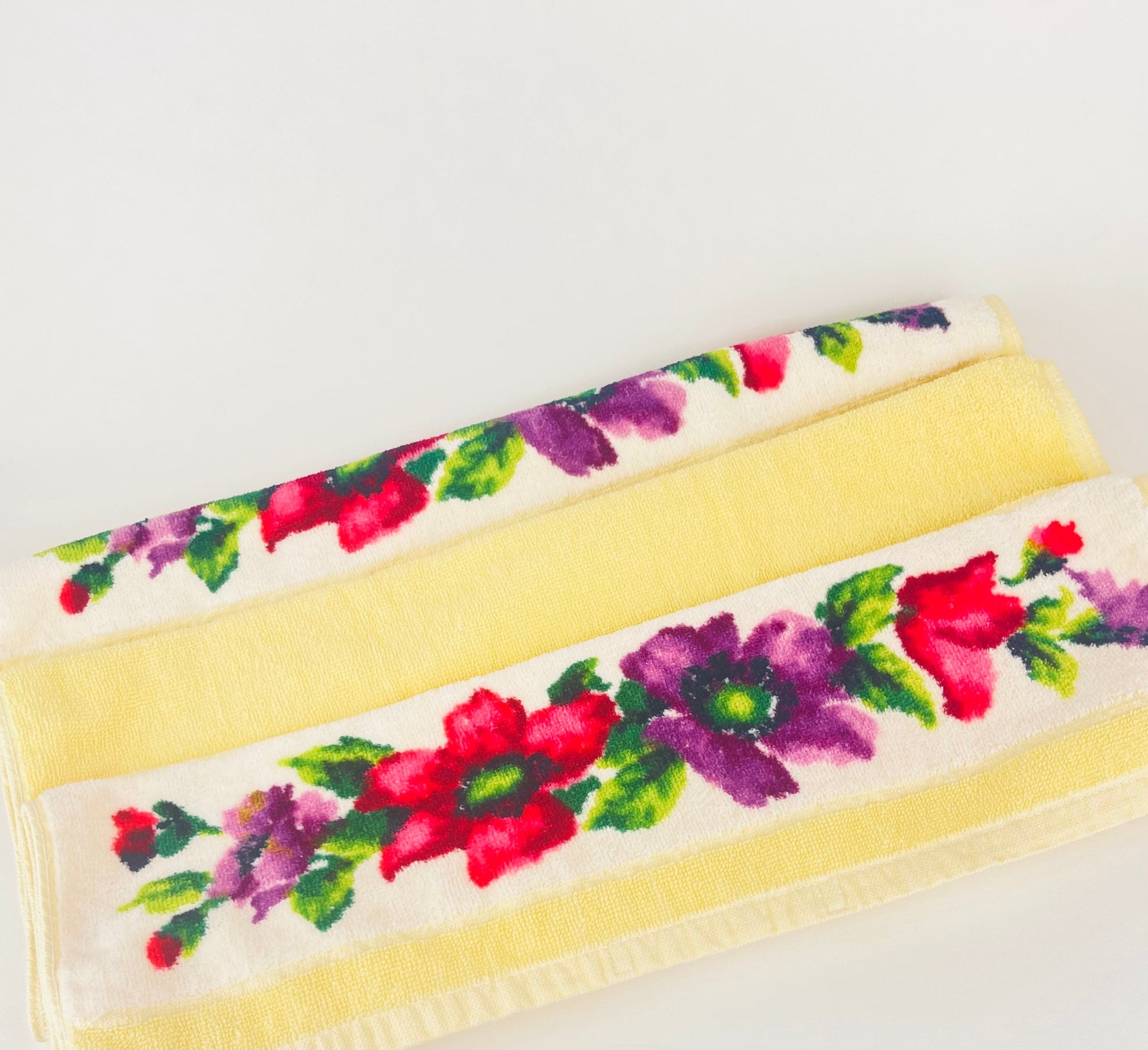 Floral towels with a yellow border on a white background