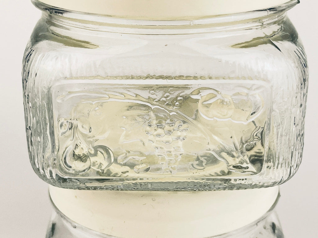 Glass jar with embossed design on a white background