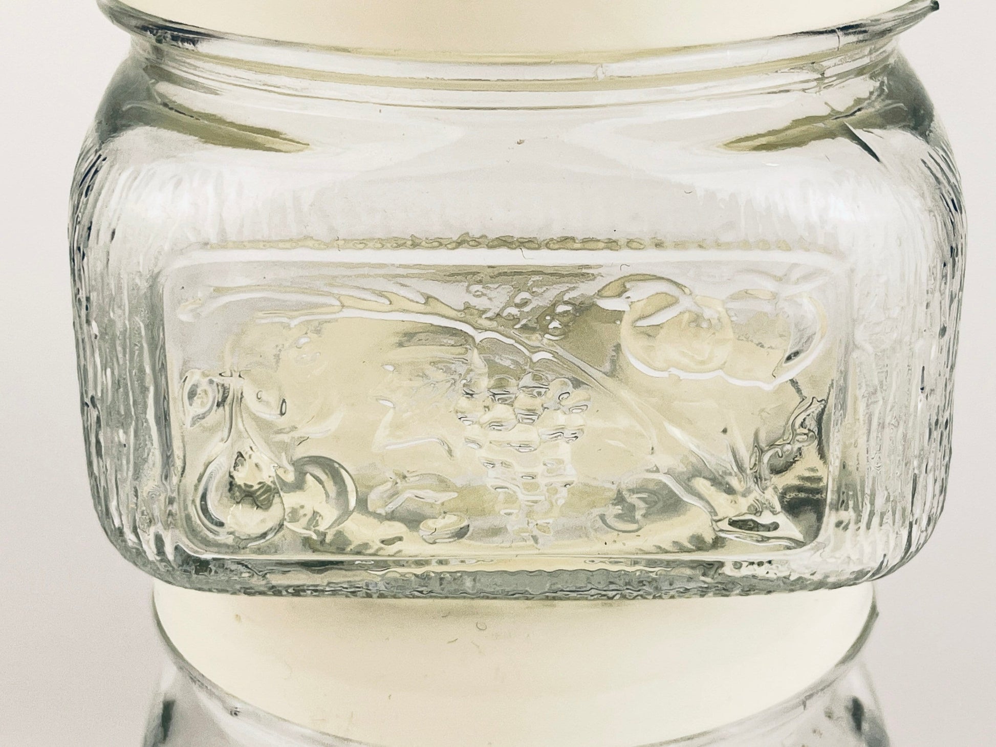 Glass jar with embossed design on a white background
