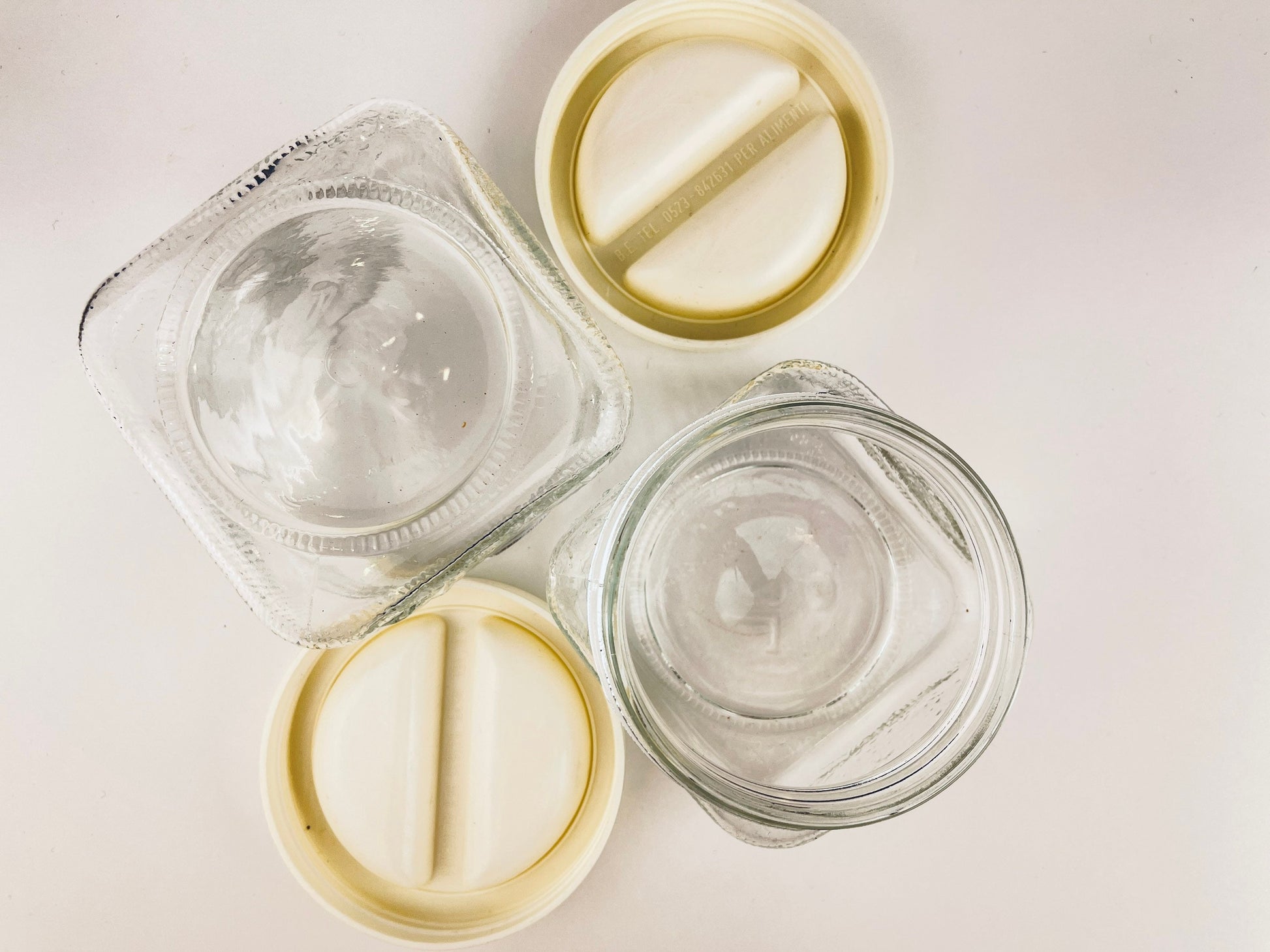 Clear glass containers with white lids on a light background
