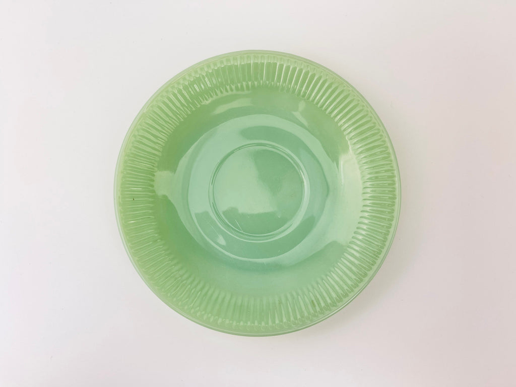Green jadeite saucer on a white background