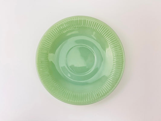Green jadeite saucer on a white background