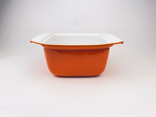 Orange and white dish on a light gray background