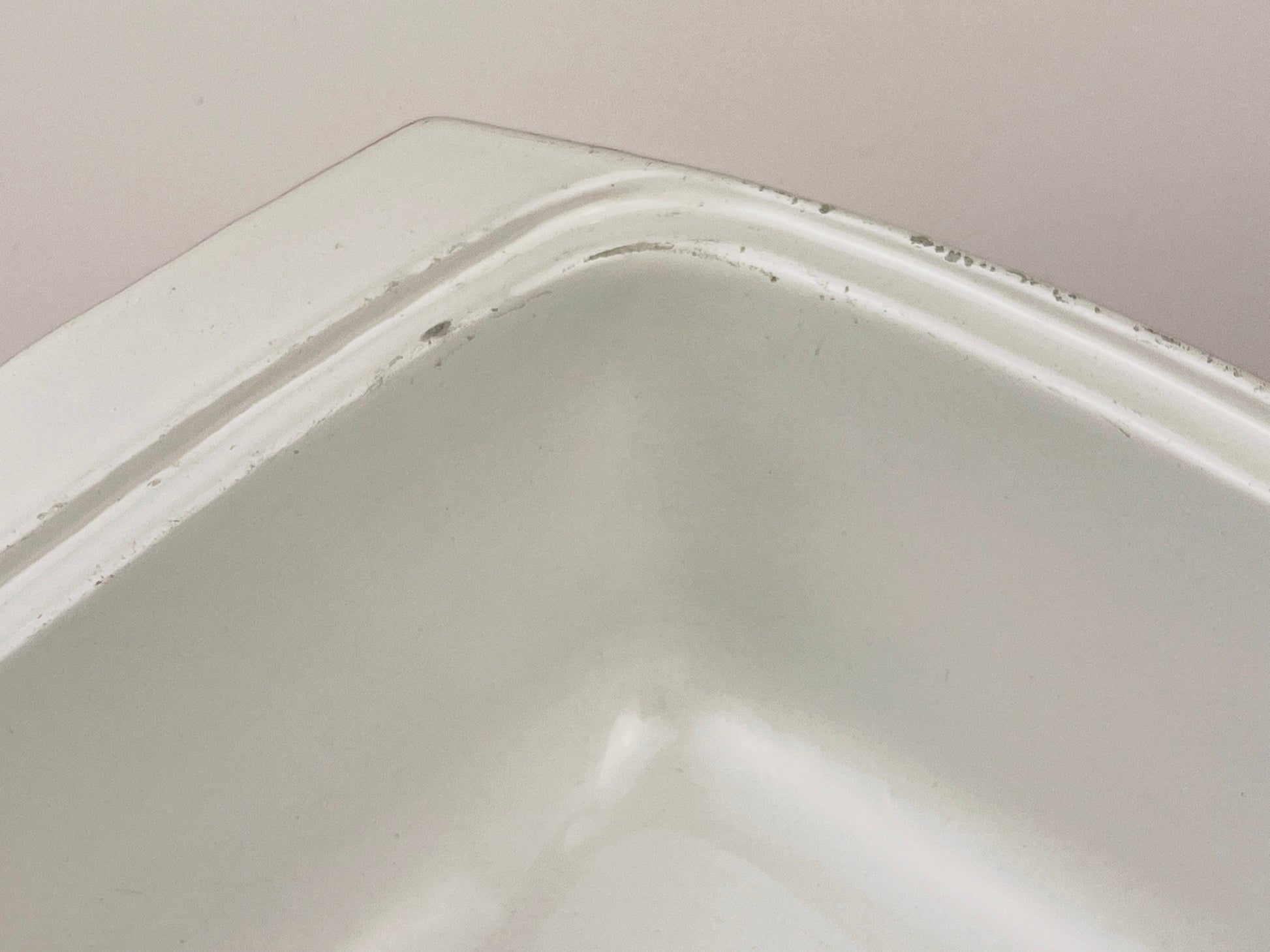 White ceramic coated  cast iron square bowl on a light gray background