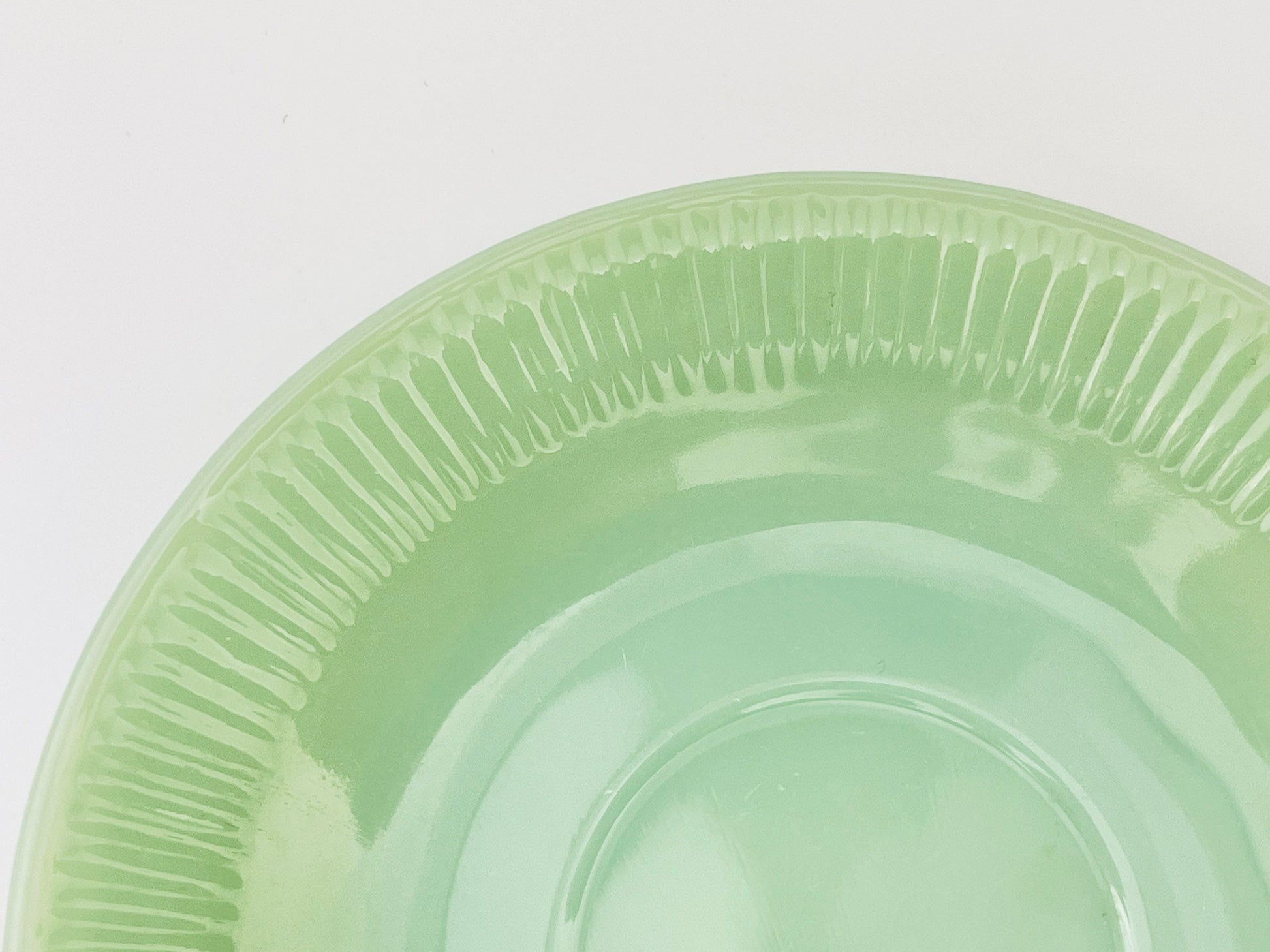 Green jadeite saucer on a white background