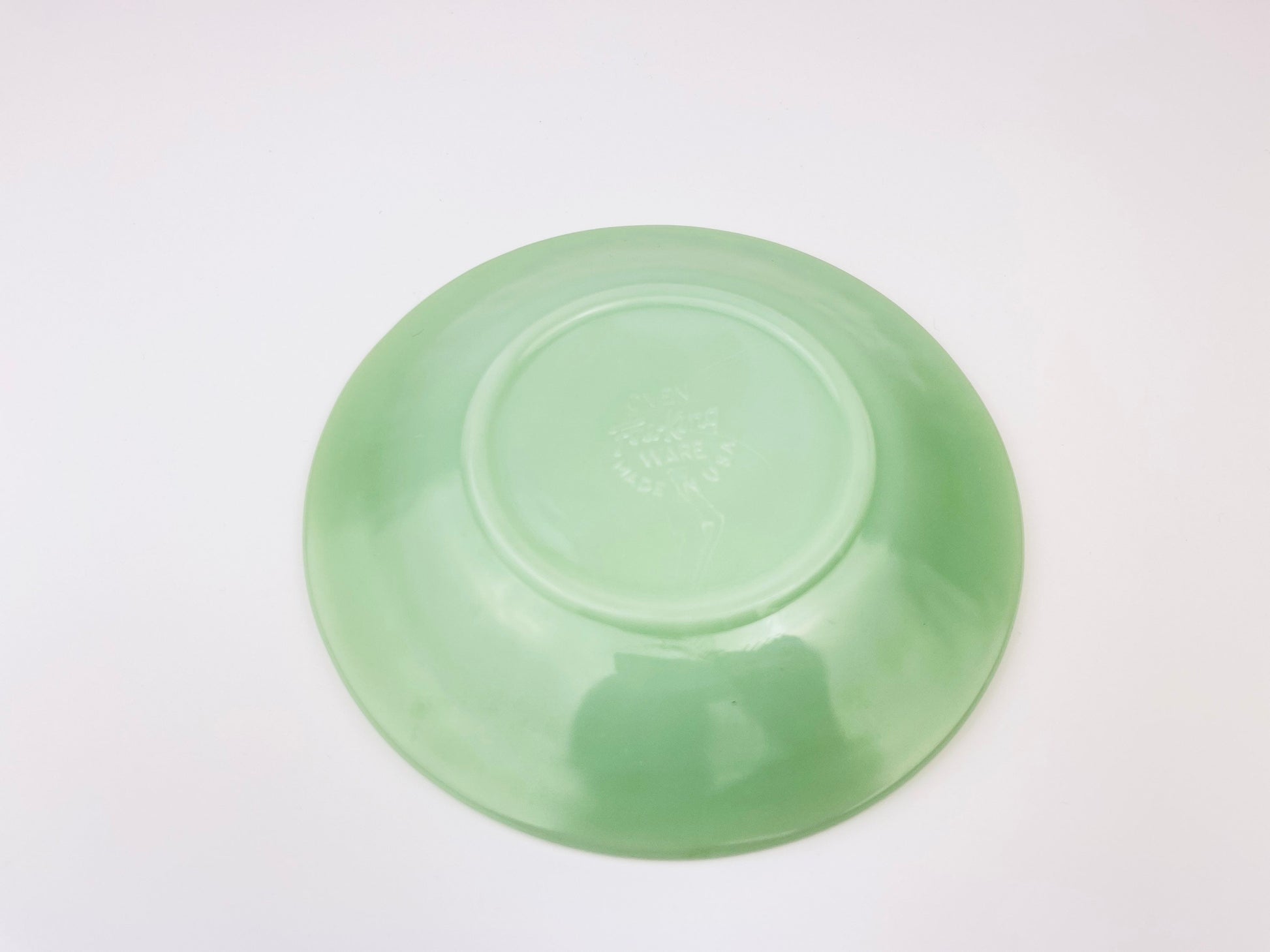 Green jadeite saucer on a white background