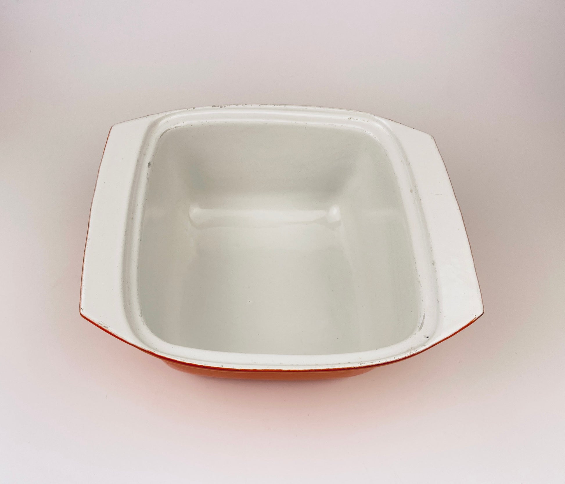 White ceramic coated  cast iron square bowl on a light gray background