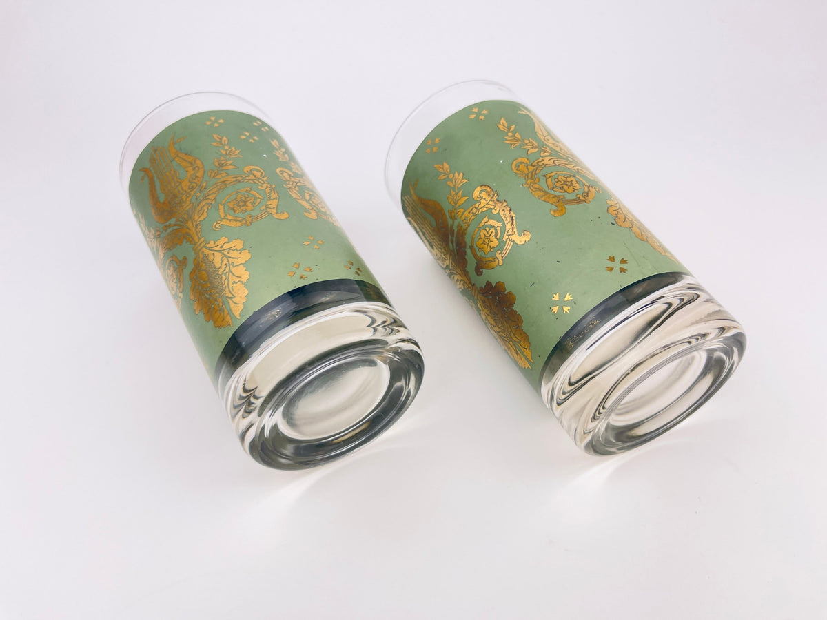 Two green tumblers with gold patterns on a white background