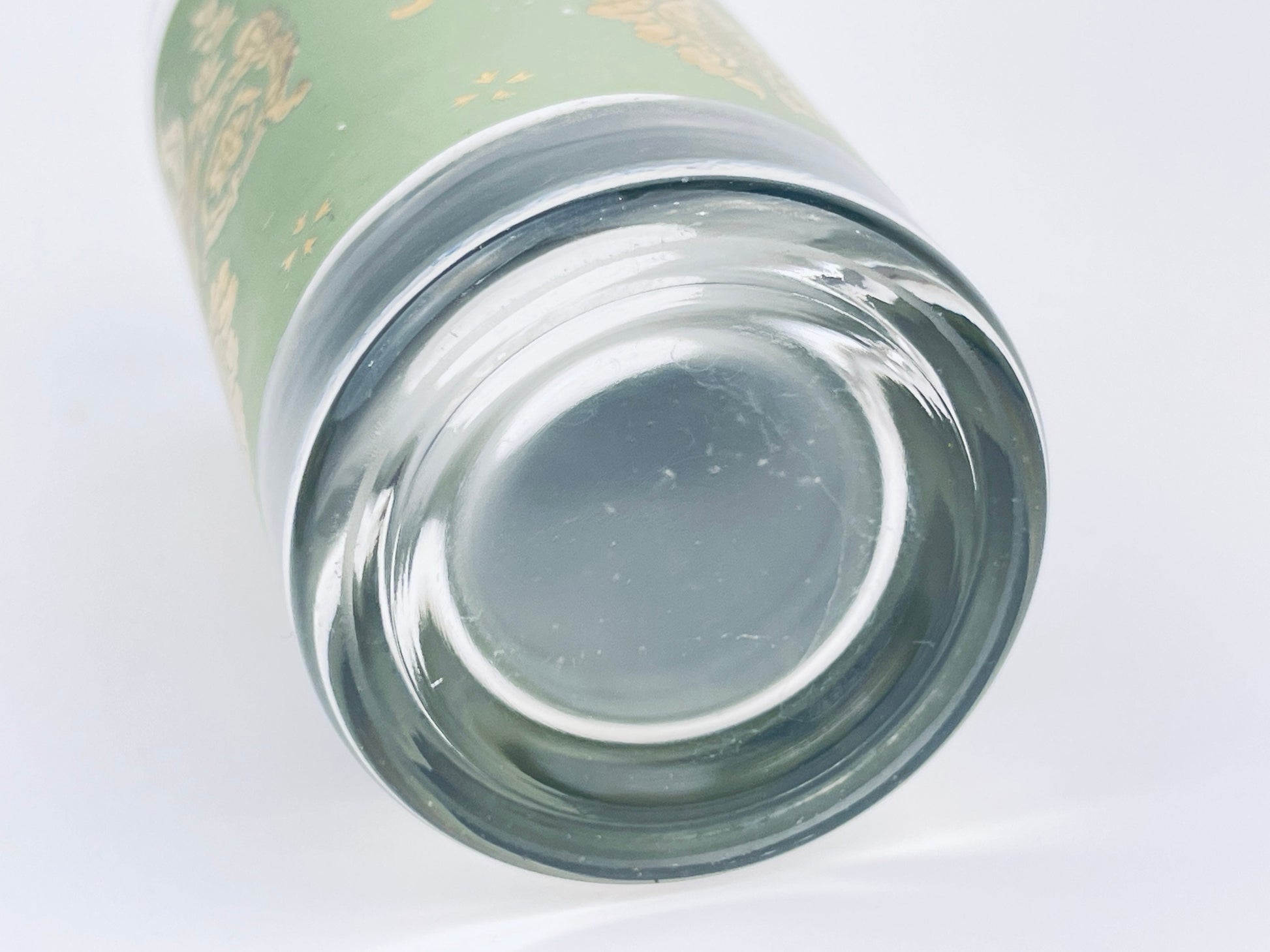 Close-up of a glass tumbler with a green label on a white background