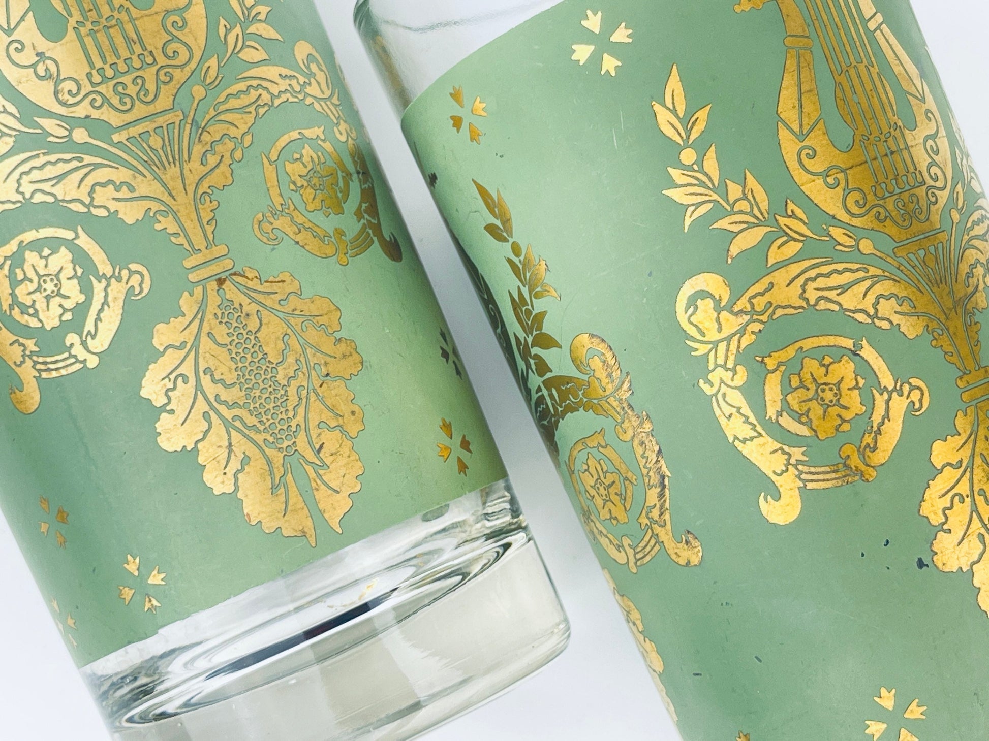 Green glass with gold decorative patterns on a white background