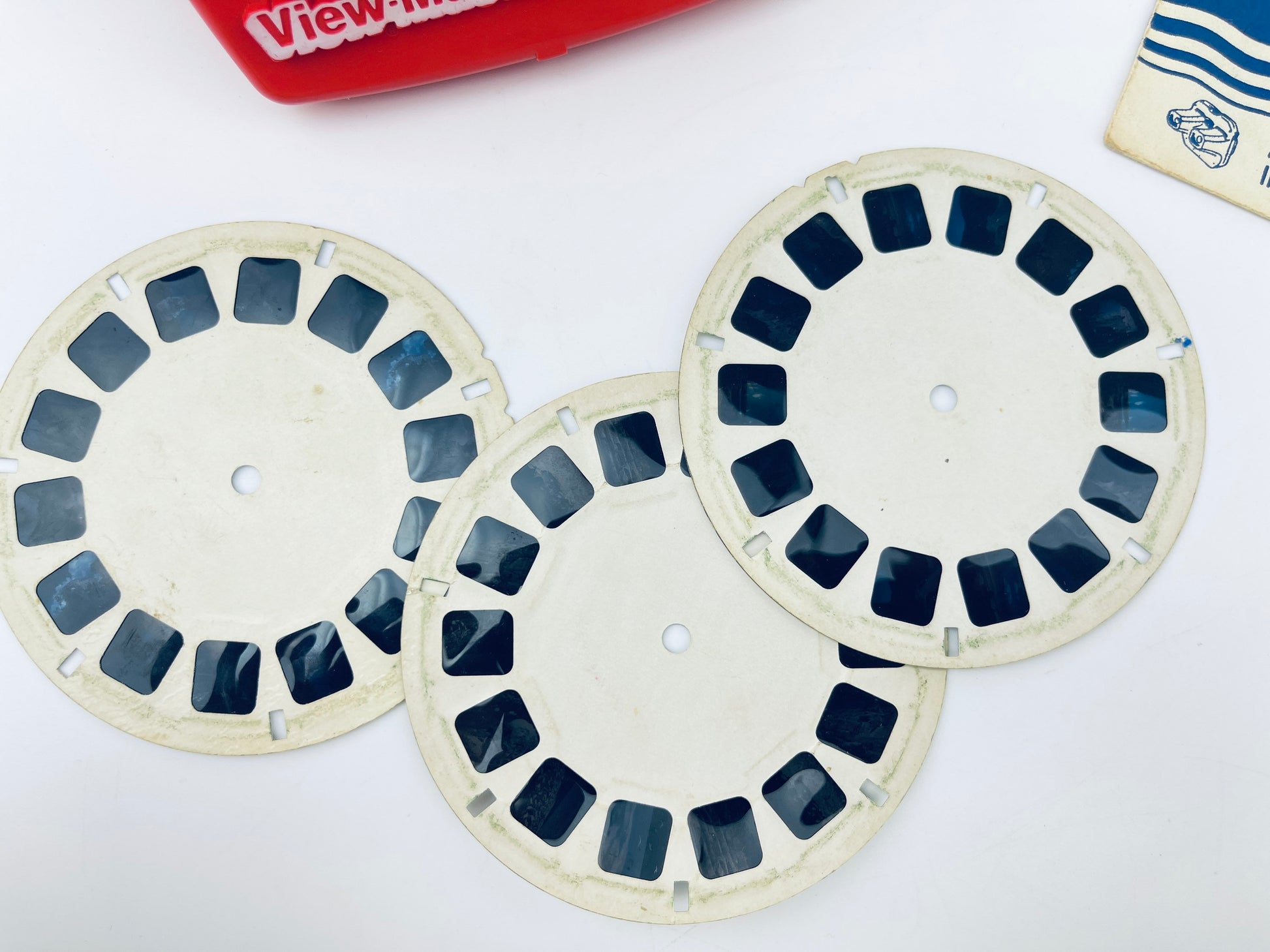 Three View-Master reels on a white background with a View-Master box in the corner.