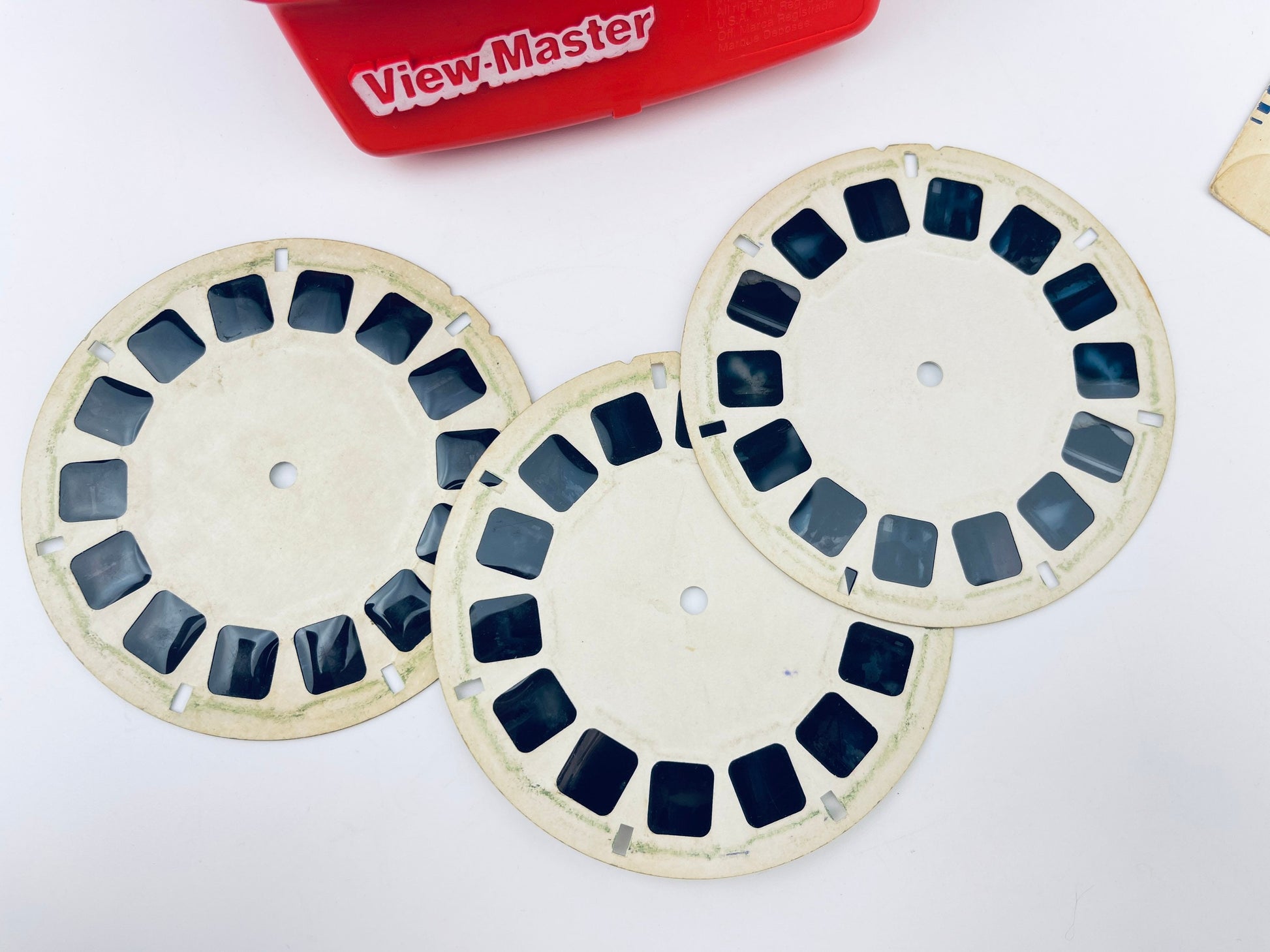 Three View Master reels on a white background with a red View Master box in the background.