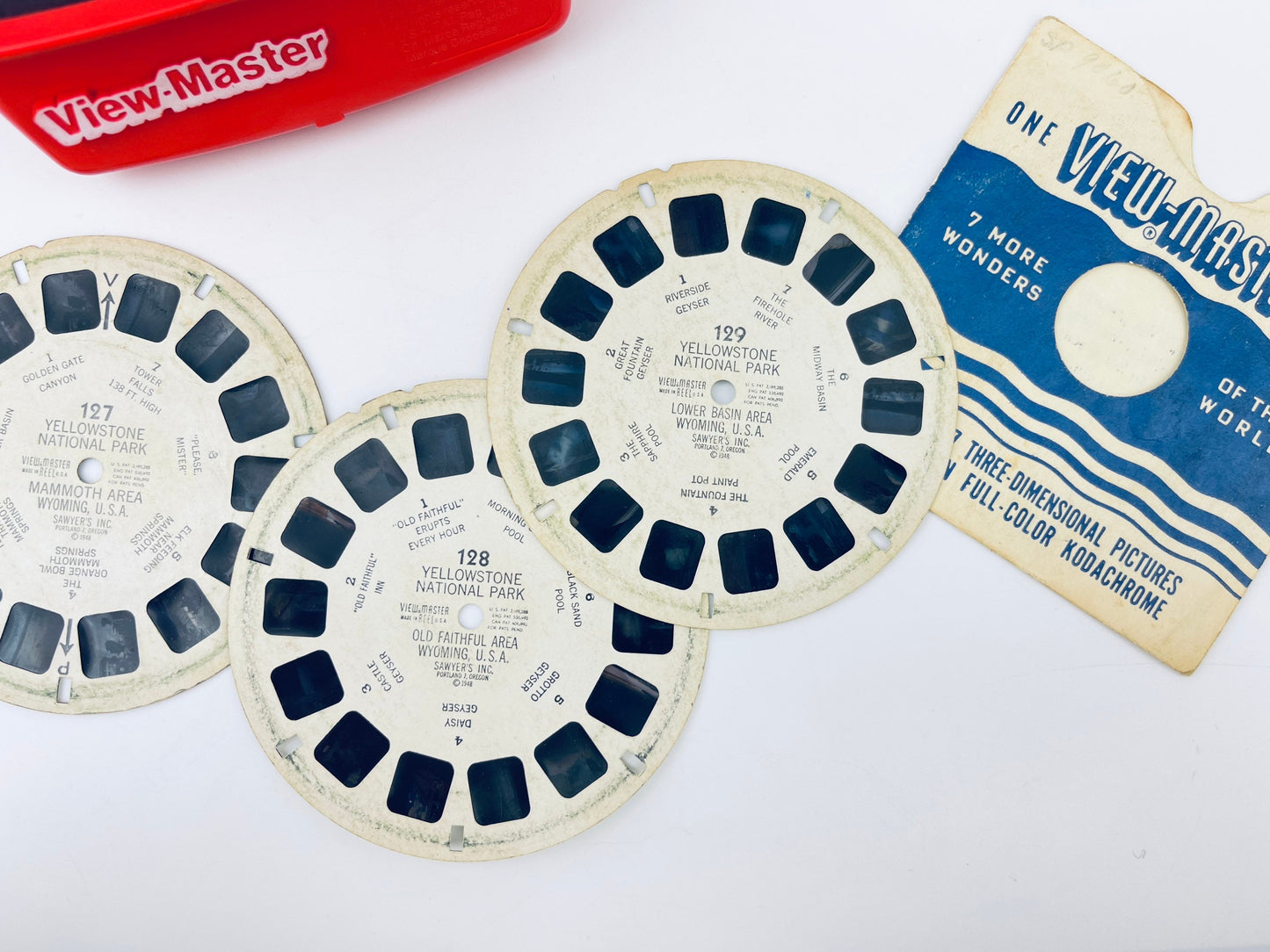 Three View-Master reels with a View-Master box on a white background