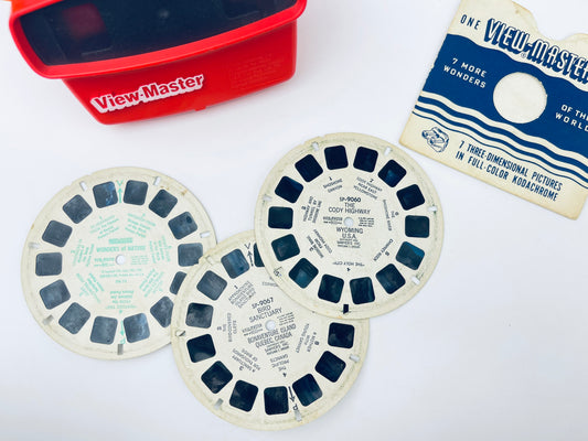 Three View-Master reels with a red View-Master box and View-Master paper on a white background.