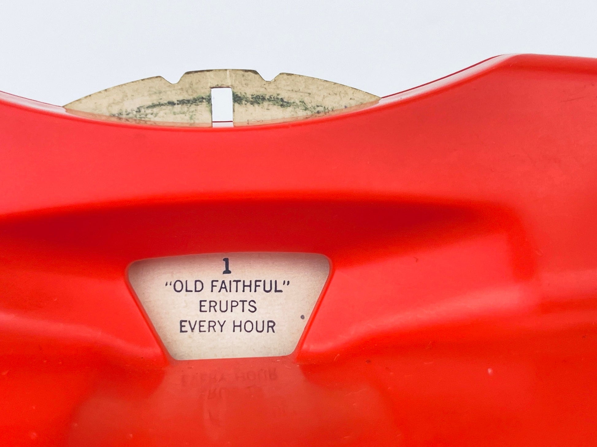 Close-up of a red object with 'Old Faithful' text on a white background