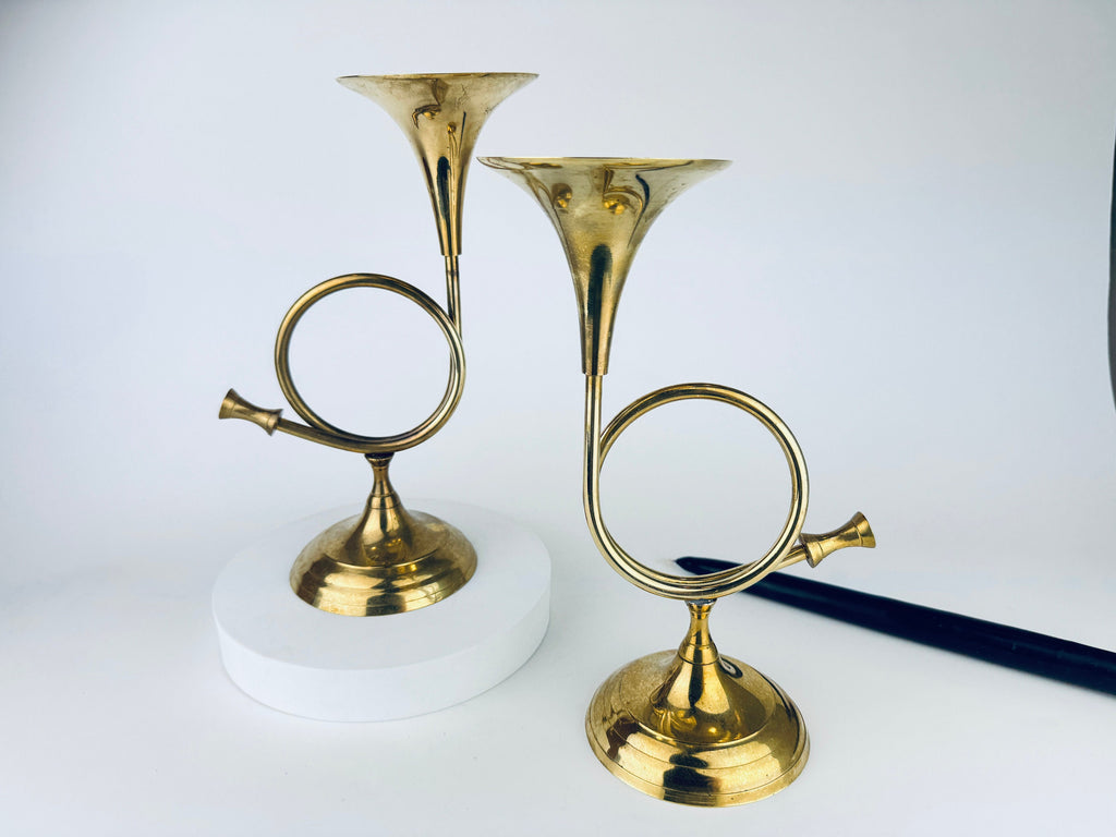 Pair of vintage 1970s solid brass horn-shaped candlestick holders made in India, set of two on white background.