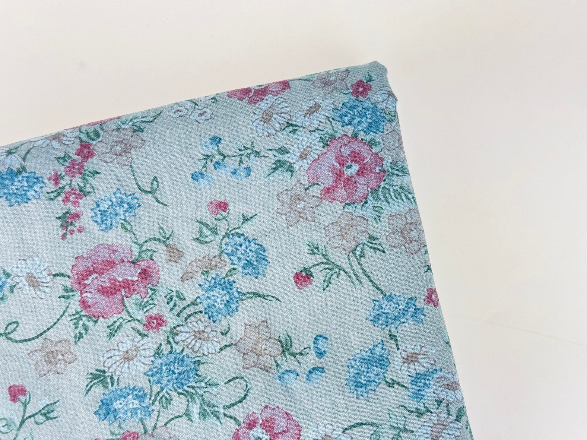 Floral fabric with pink, blue, and green flowers on a light blue background