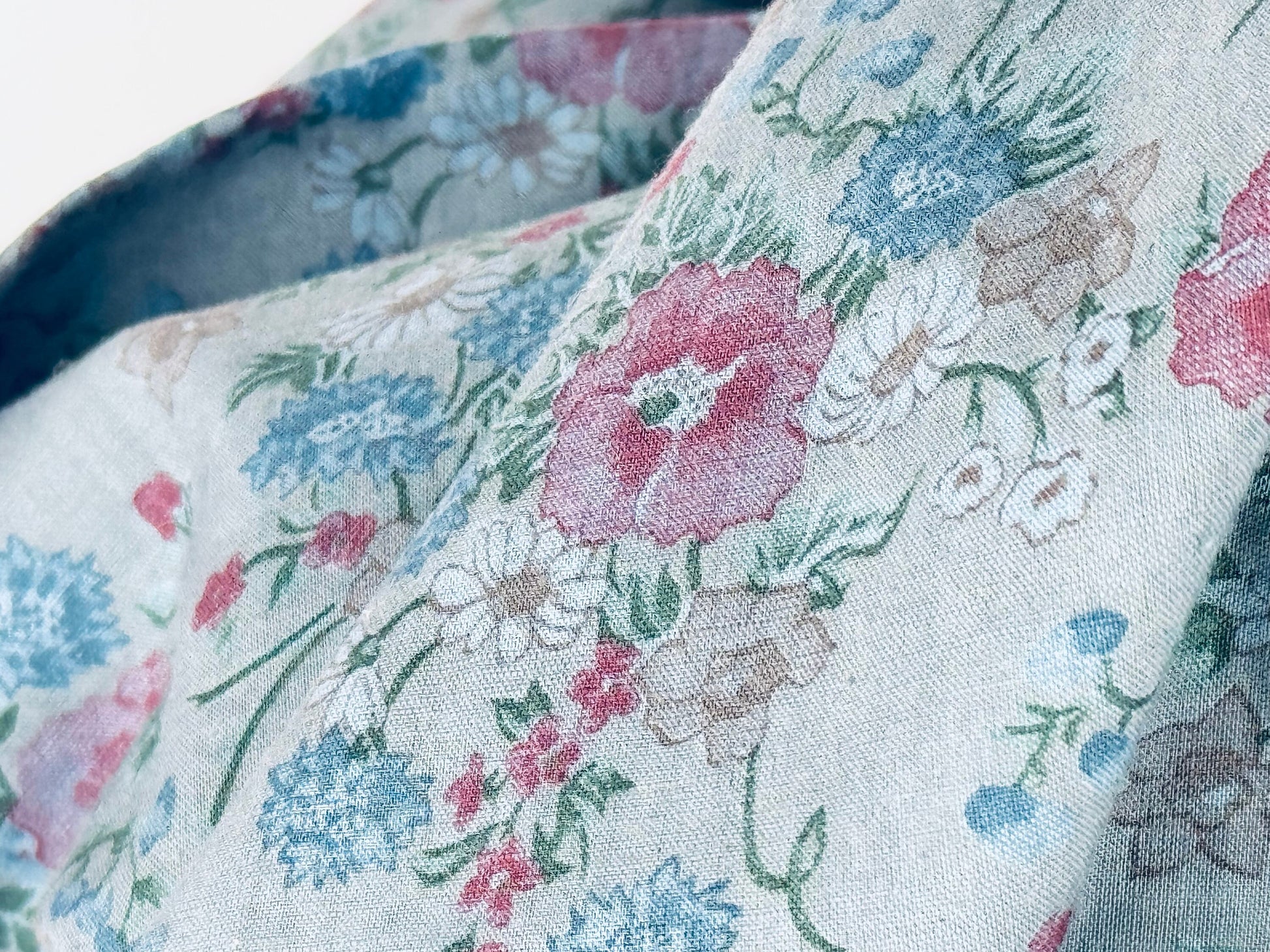 Floral patterned fabric with pink, blue, and green flowers on a light background