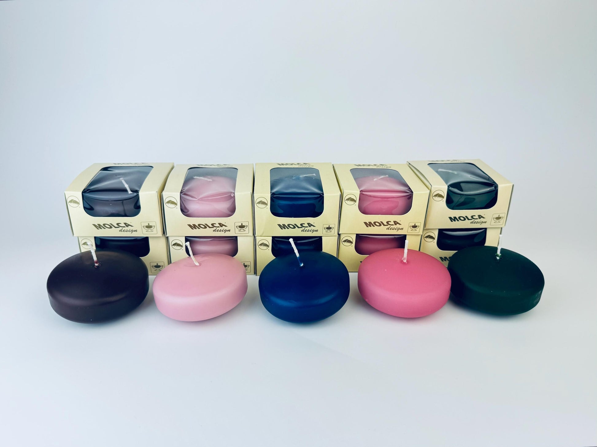 Set of colorful floating candles with packaging in the background