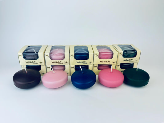 Set of colorful floating candles with packaging in the background