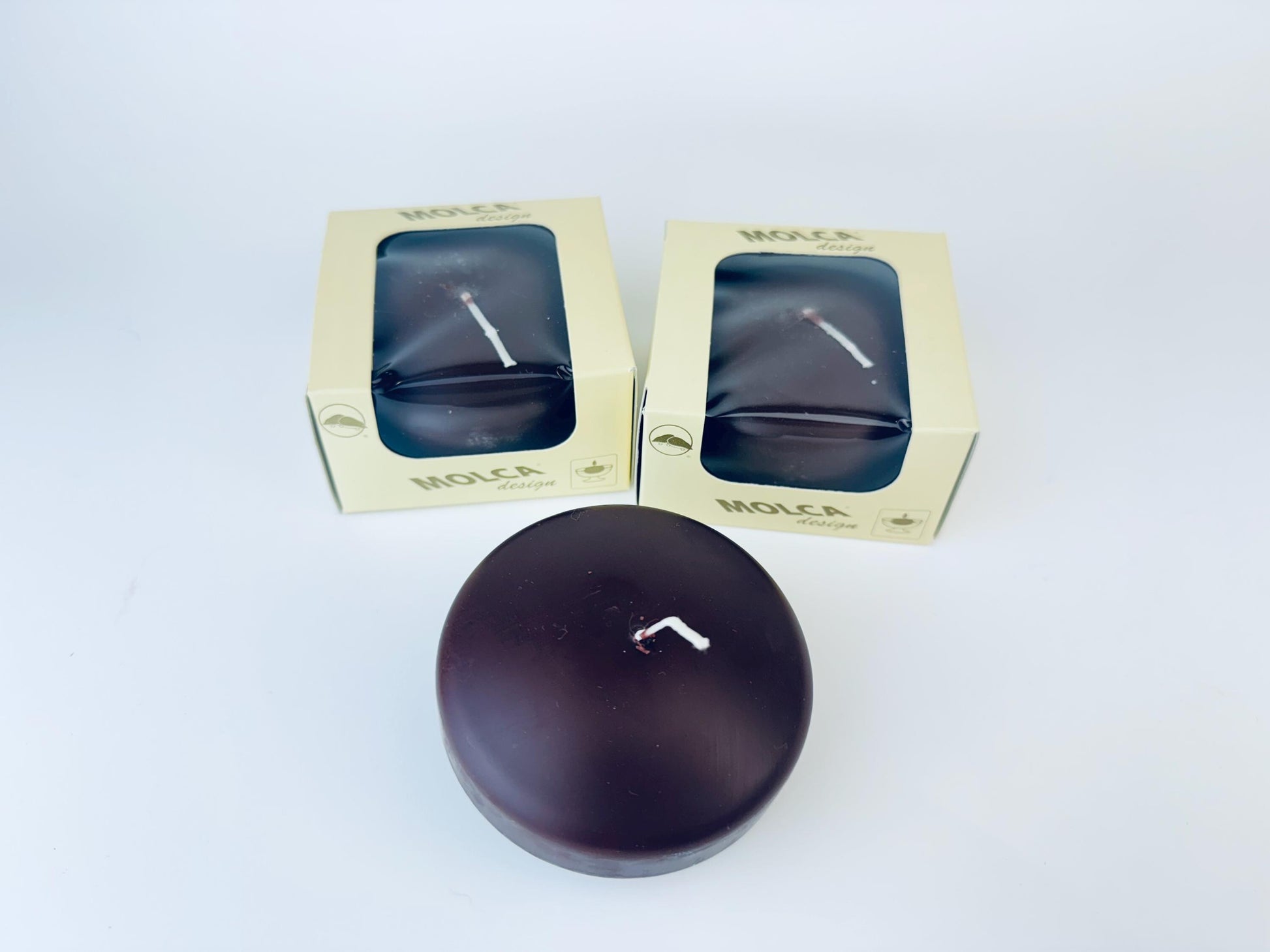Two MOLCA candles in packaging on a white background