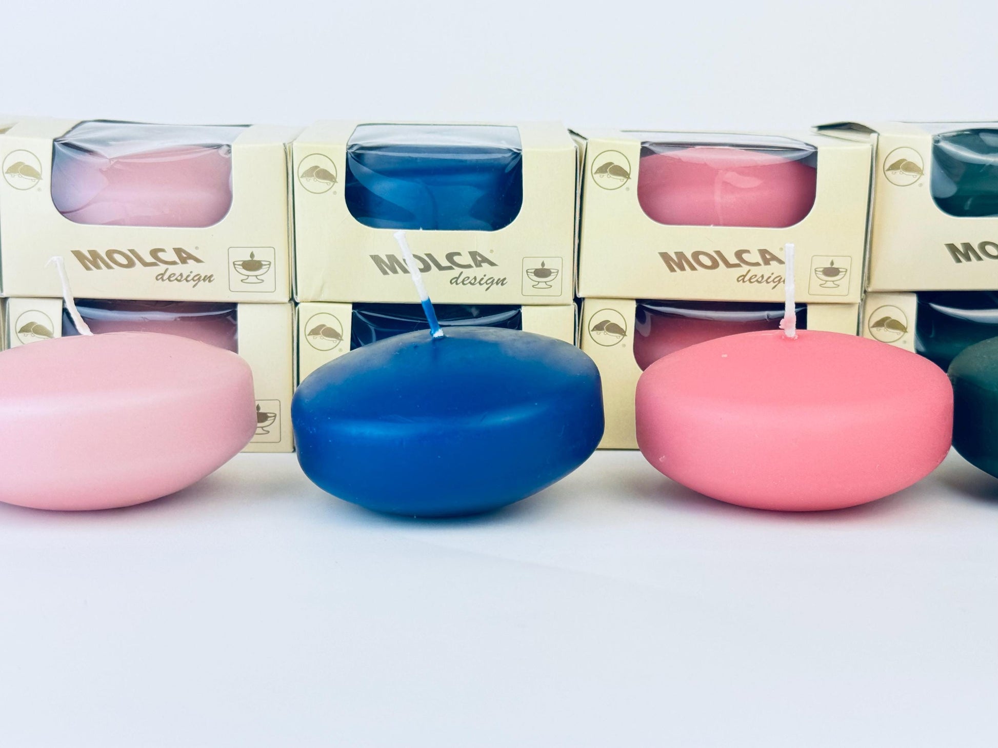 Set of colorful floating candles with packaging in the background