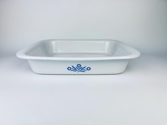 Front view of a vintage white Corning Ware Blue Cornflower P-21 roaster pan against a clean white background.