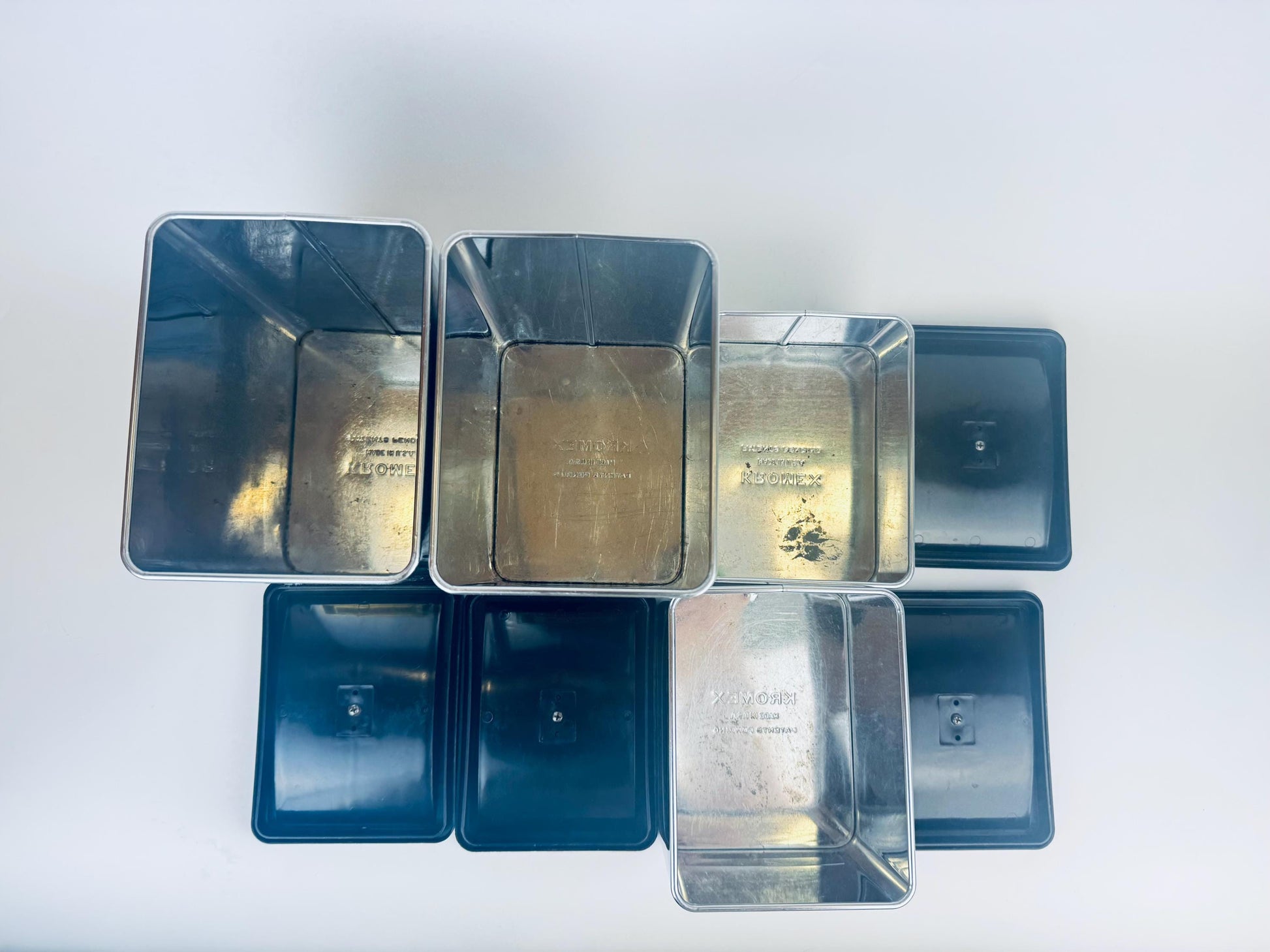 Set of metal containers with lids on a white background