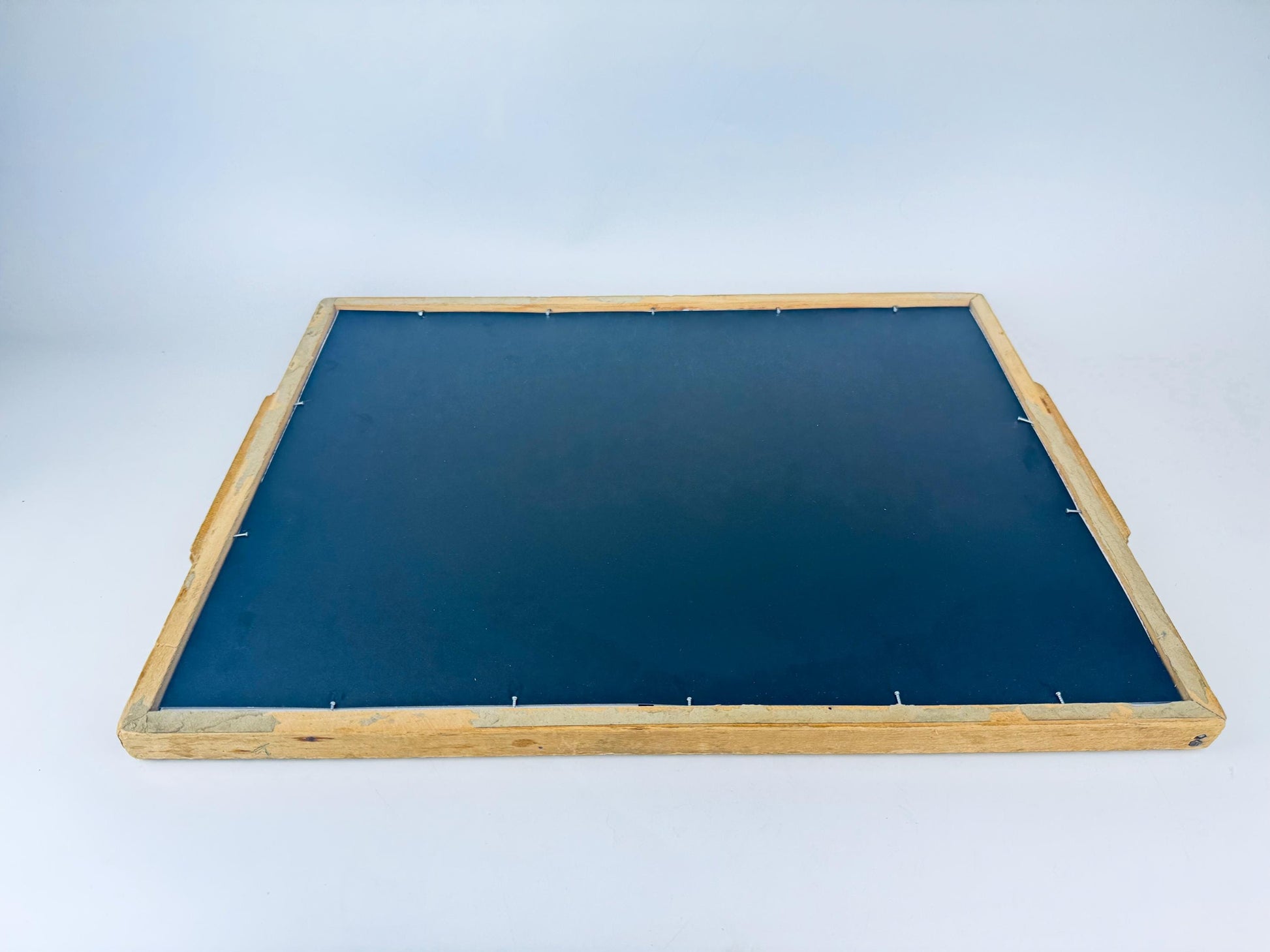 Back of framed botanical illustration of flowers in carved wooden handled tray. 