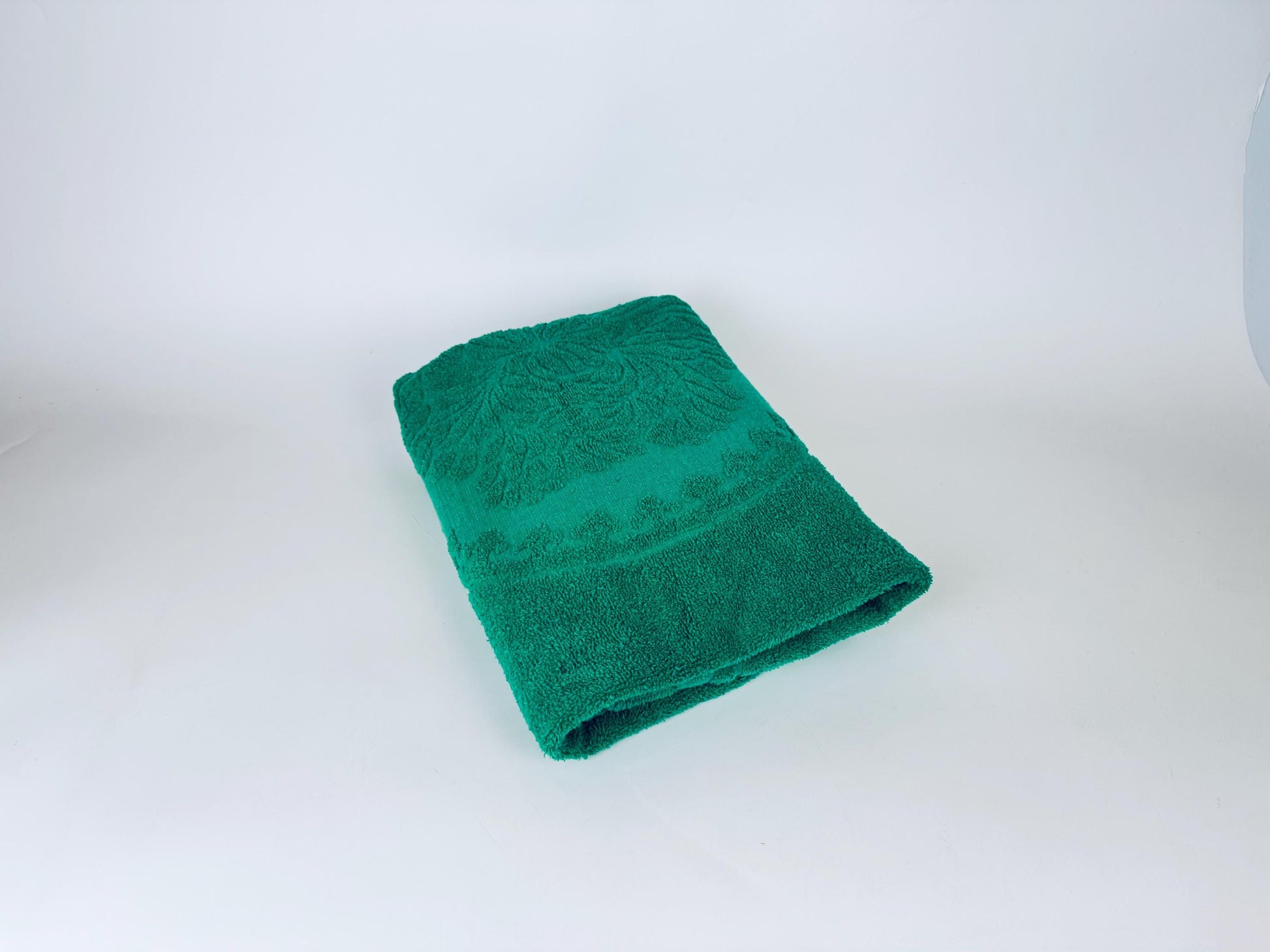 Green towel with a pattern on a white background
