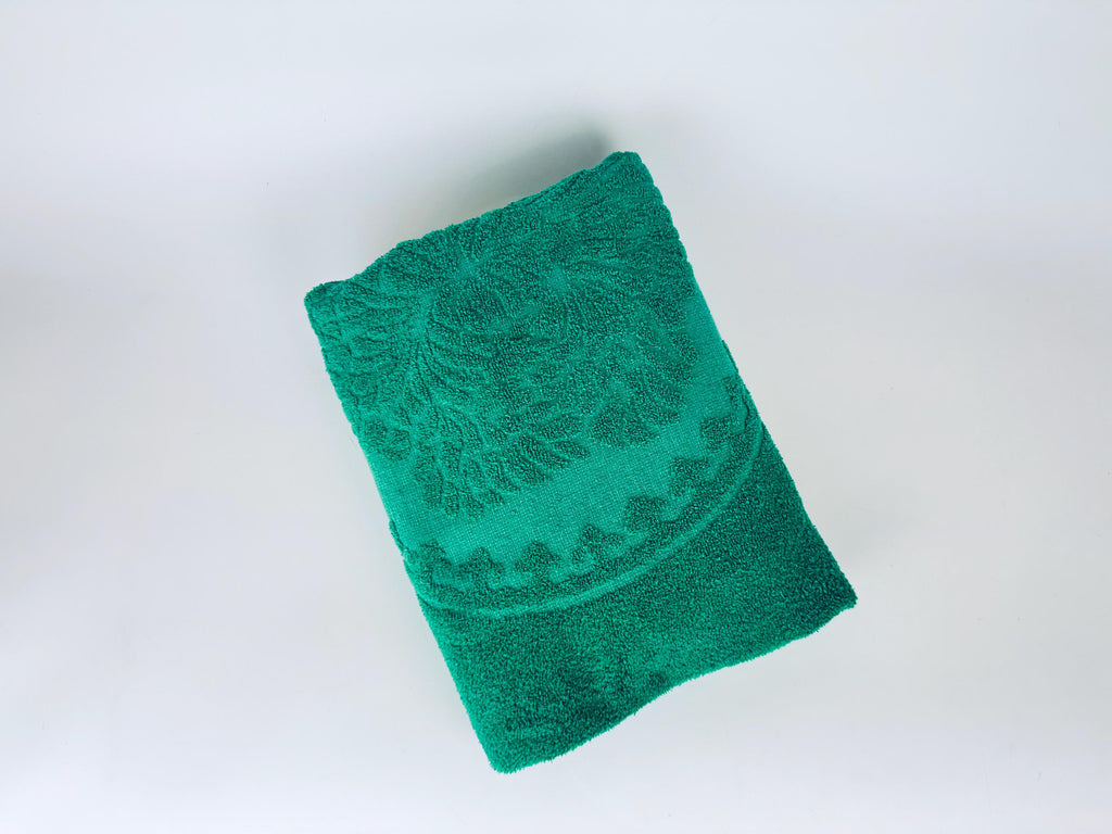 Green towel with a pattern on a white background