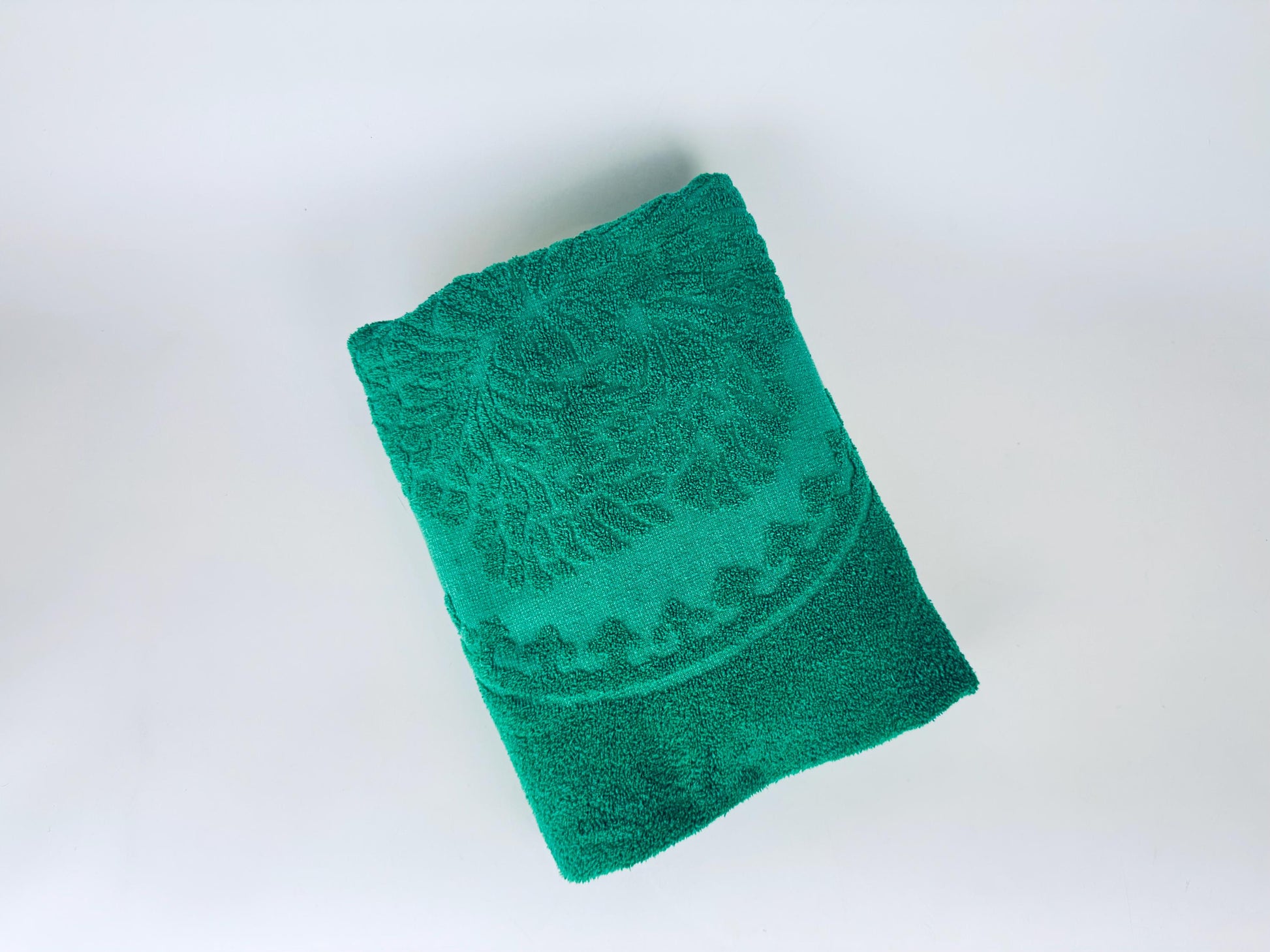 Green towel with a pattern on a white background