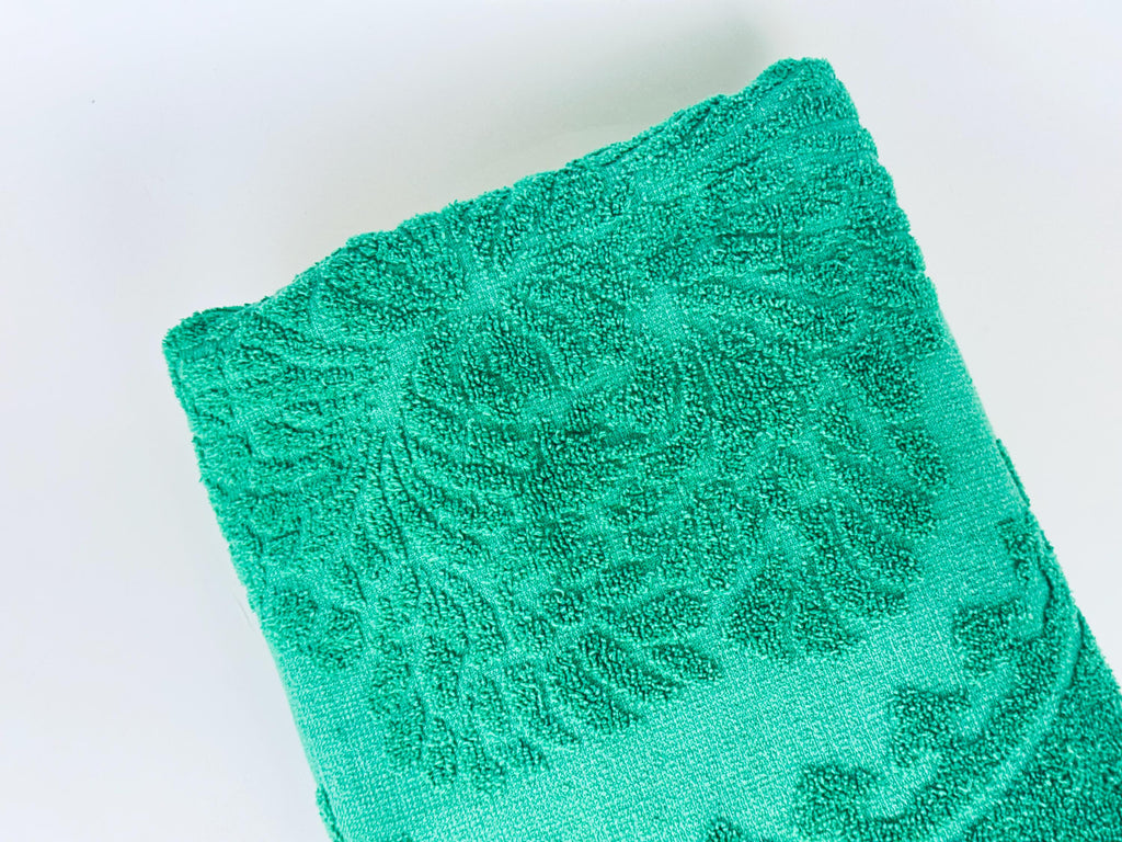 Green towel with a pattern on a white background