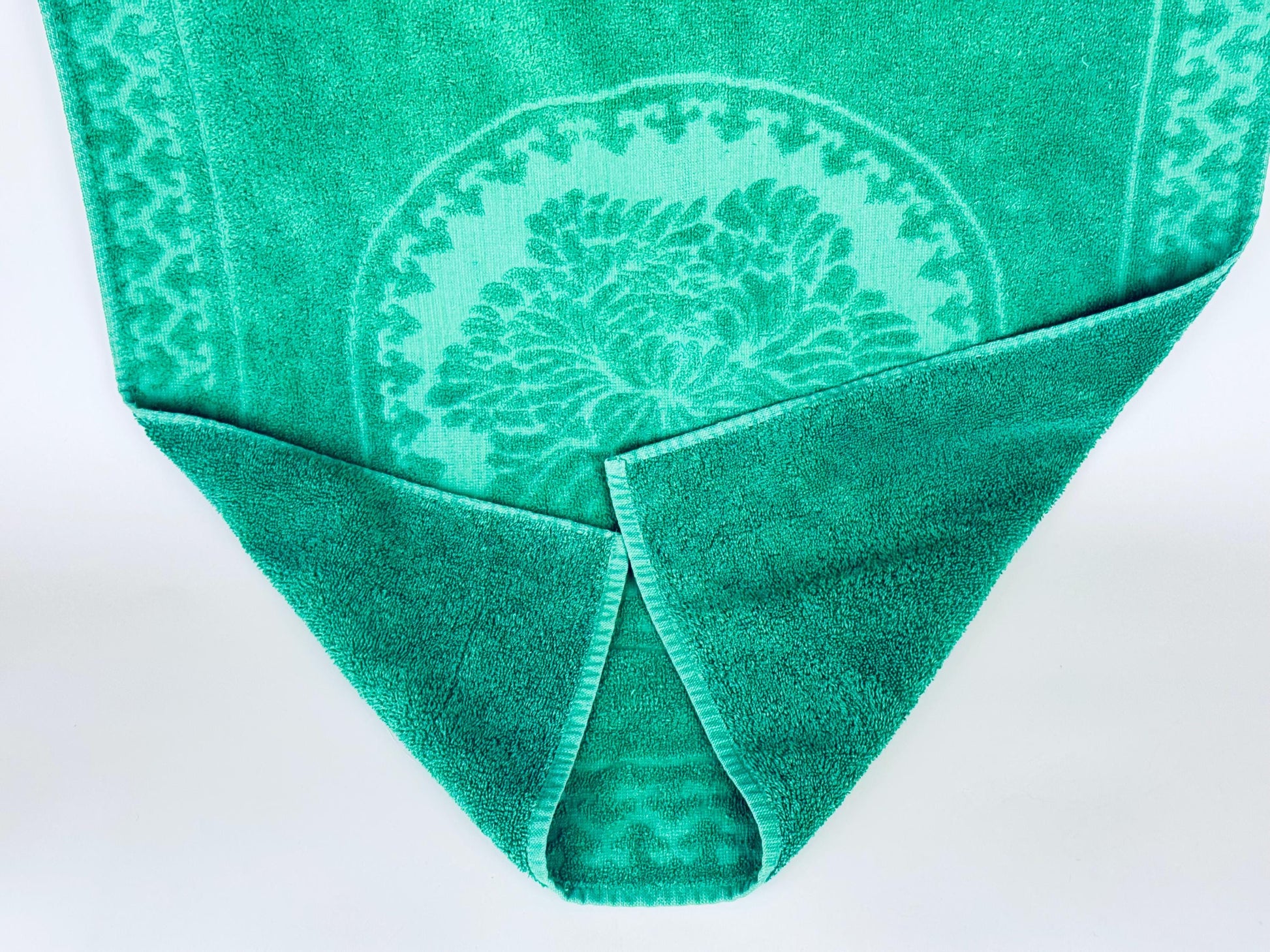 Green towel with a pattern on a white background