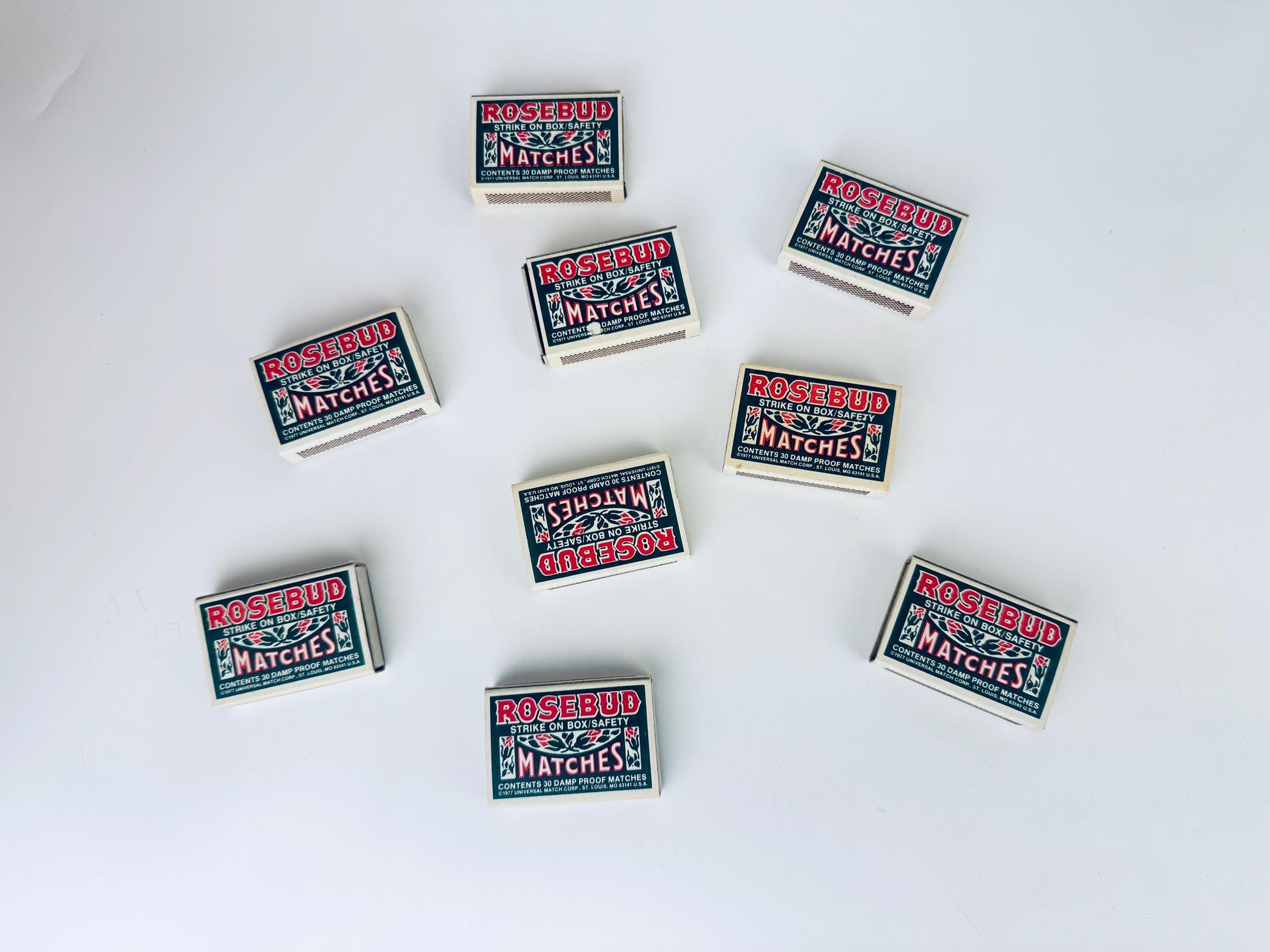 Multiple boxes of matches labeled 'Rosebud Matches' on a white background