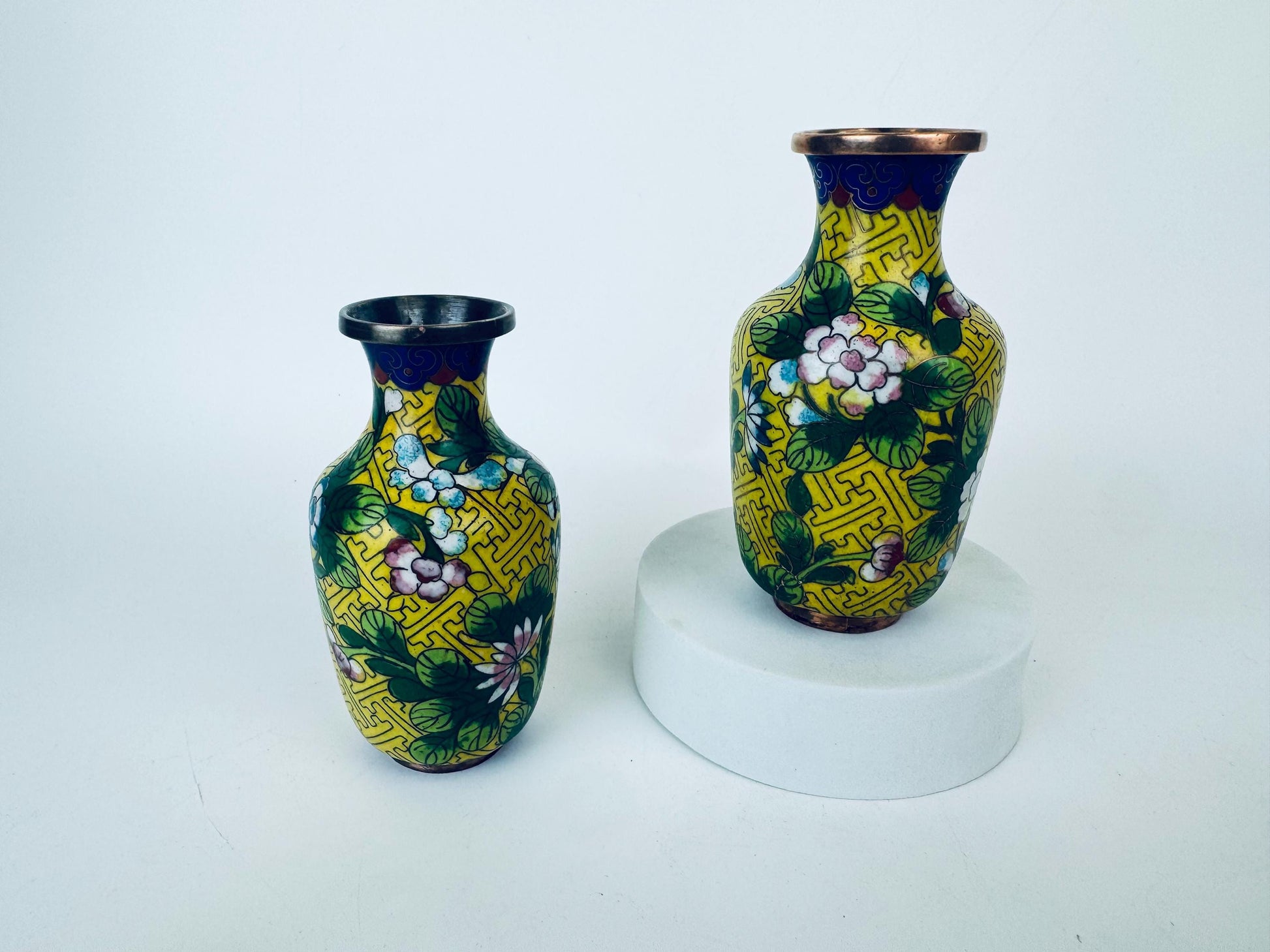 Two decorative vases with floral patterns on a white background