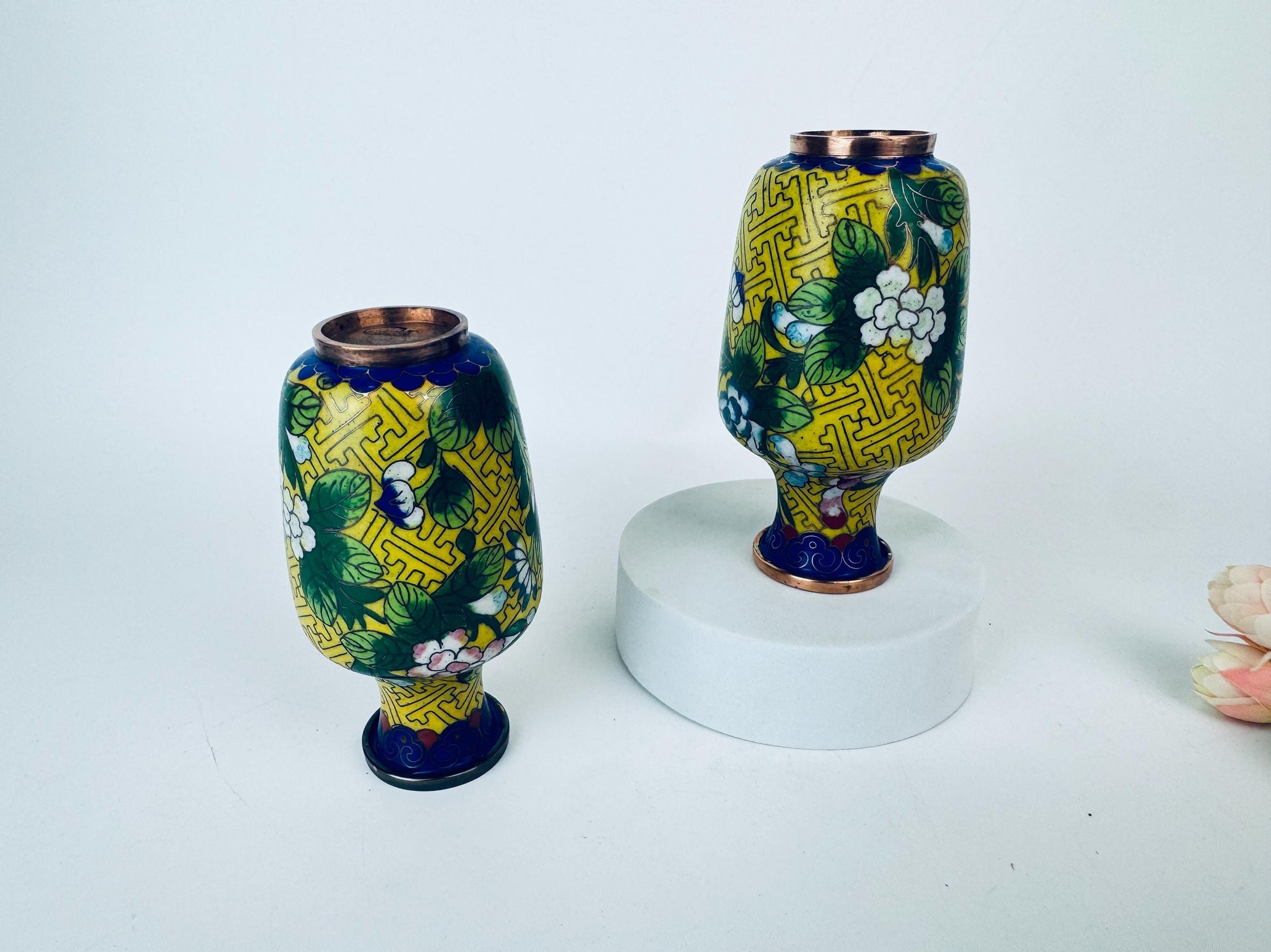 Two decorative vases with floral patterns on a white background