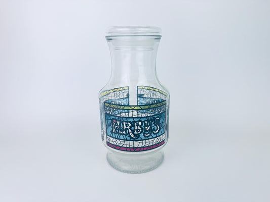 Clear glass bottle with decorative label on a white background