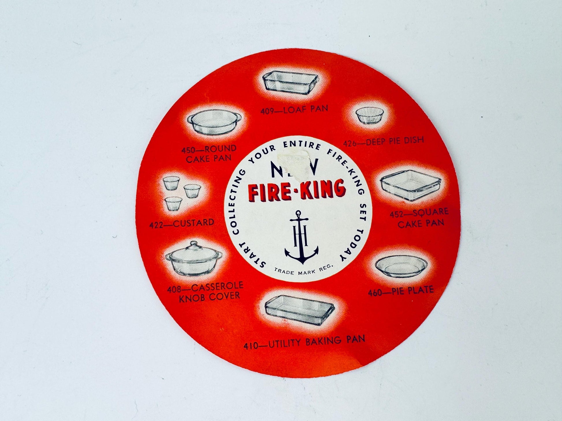 Circular Fire-King product display with various baking pans on a white background