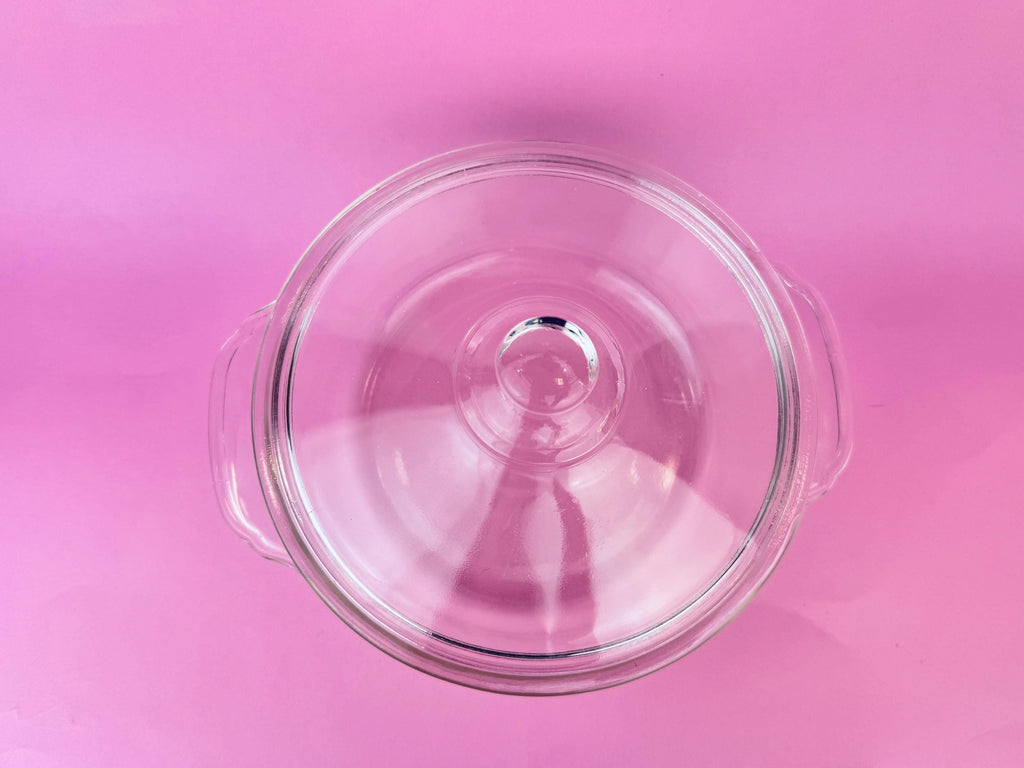 Clear glass lid on a pink background