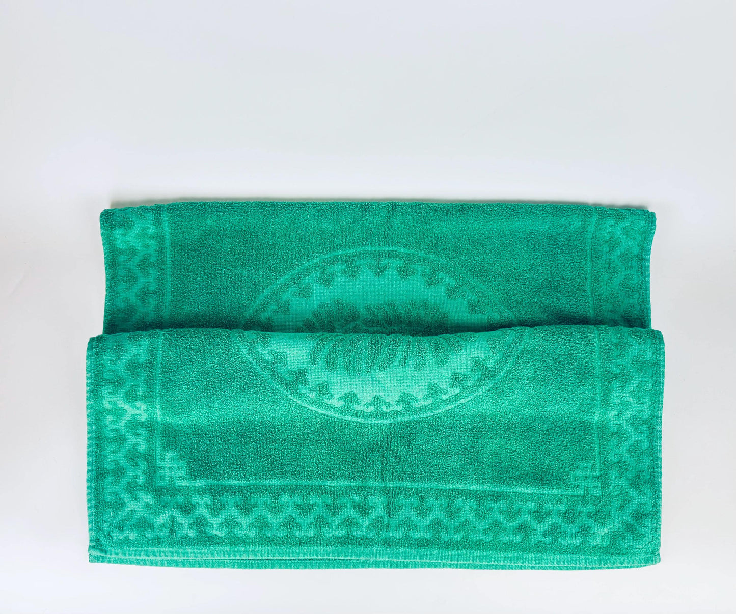 Green towel with a pattern on a white background
