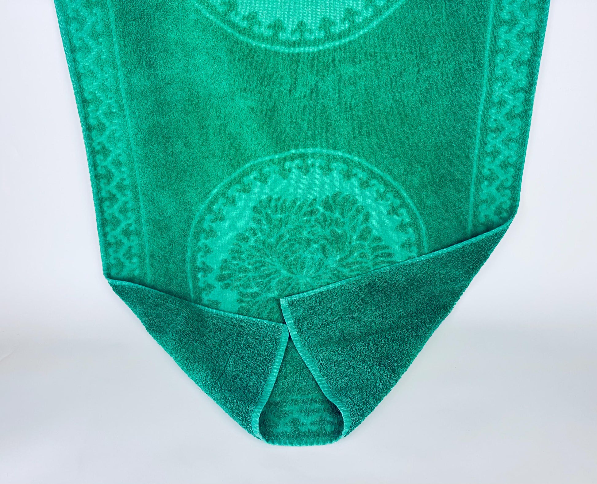 Green towel with a pattern on a white background