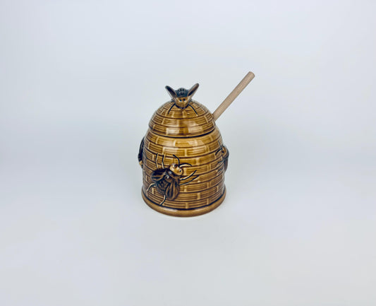Honey dipper shaped like a beehive with bees on a white background
